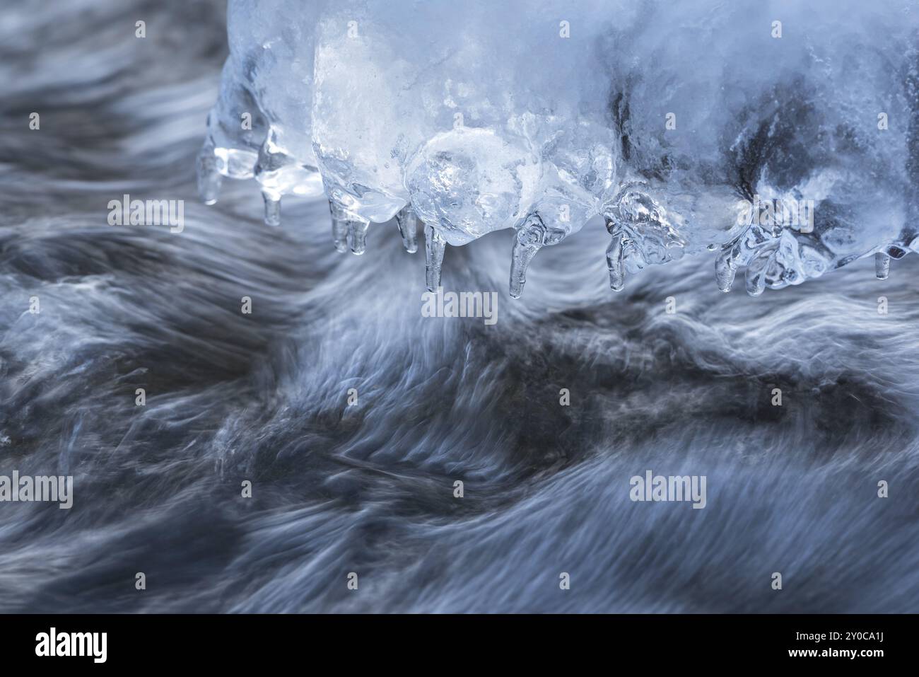 I ghiaccioli si sono formati su una pietra in un ruscello Foto Stock I ghiaccioli si sono formati su una pietra in un ruscello Foto Stock