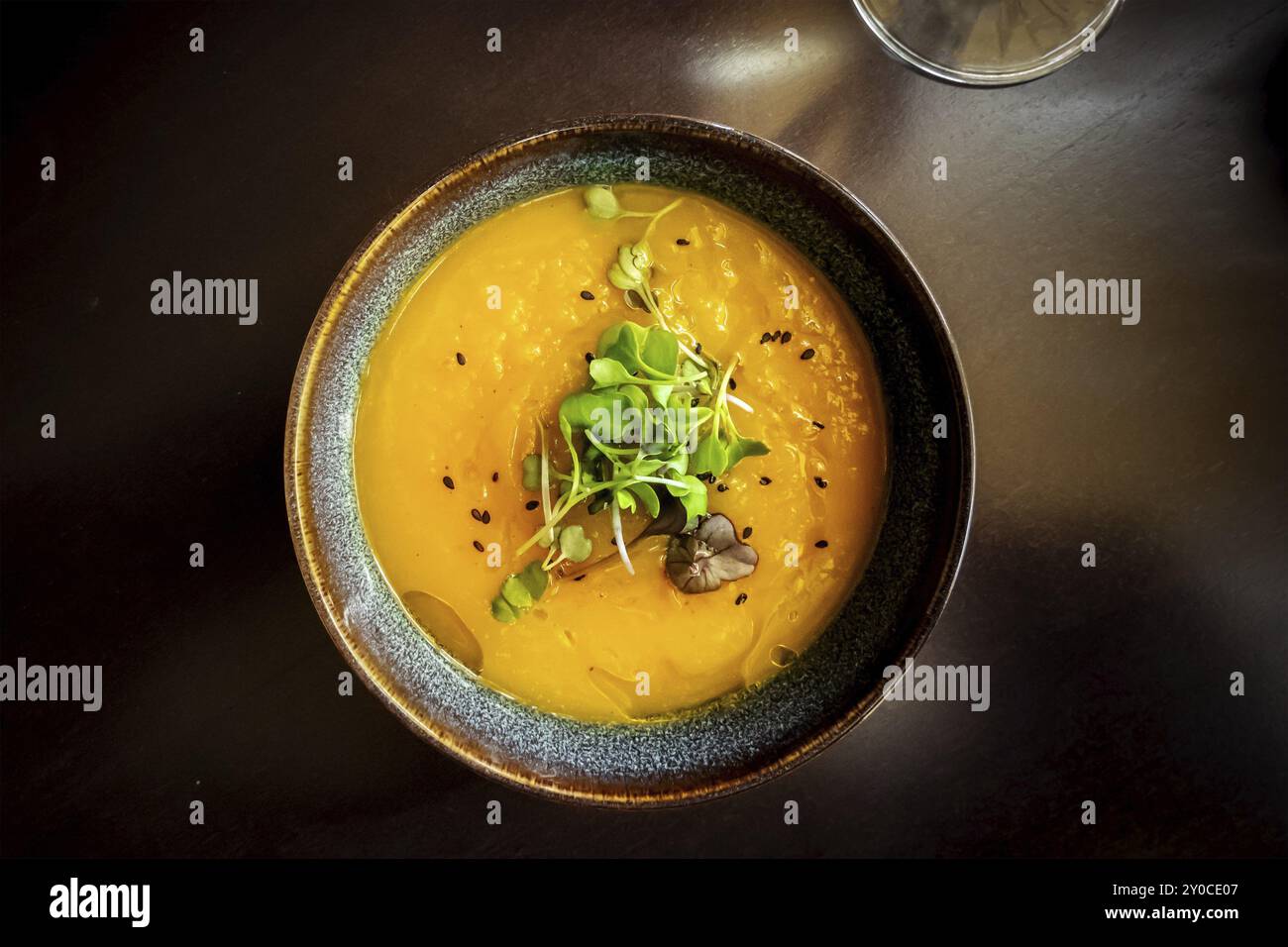 Microgreens su zuppa di zucca in un ristorante vegano, piatto elegante e salutare, foto in orizzontale, fotografia gastronomica Foto Stock