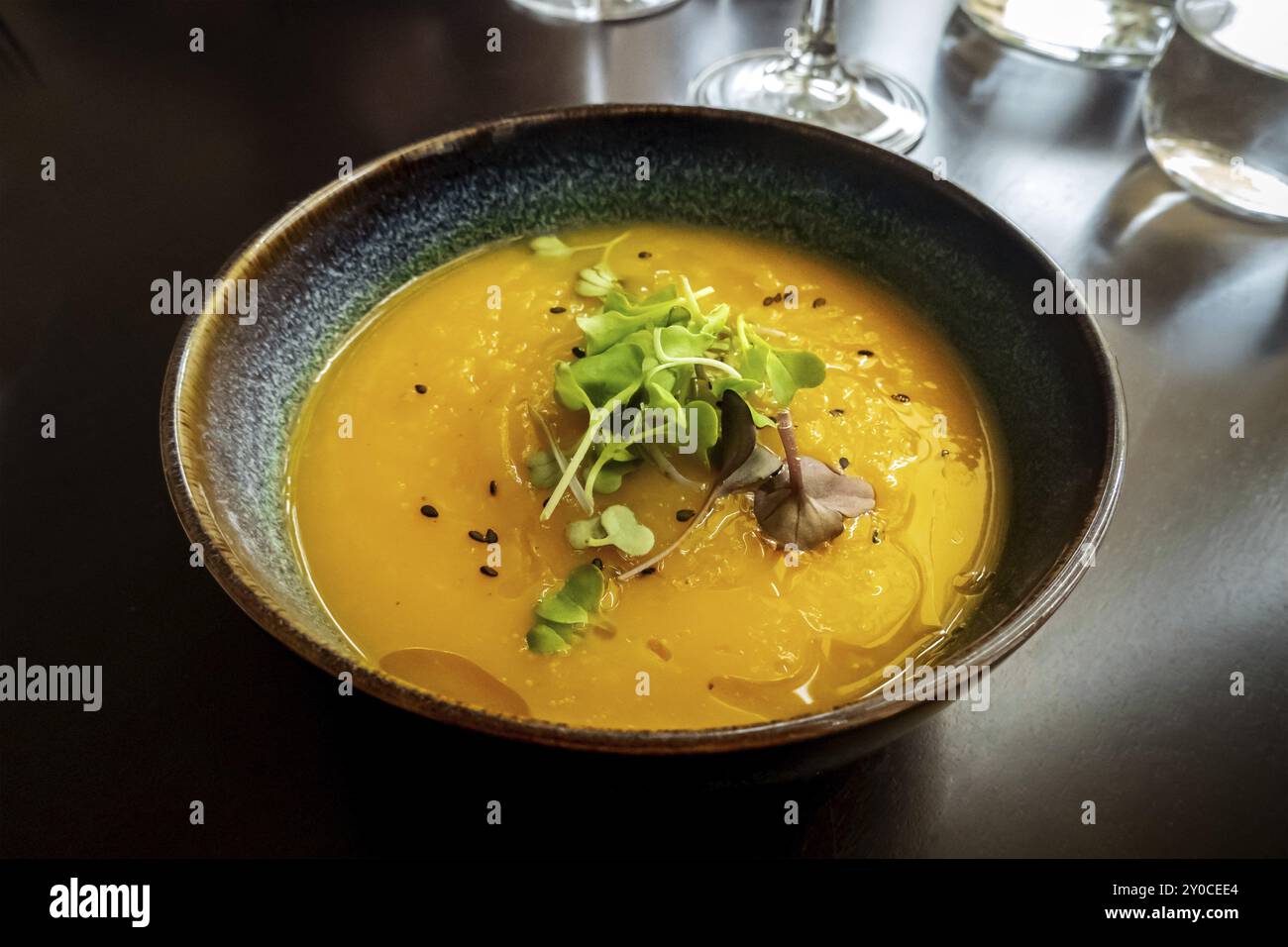 Microgreens su zuppa di zucca in un ristorante vegano, piatto elegante e salutare, foto gastronomica suggestiva Foto Stock