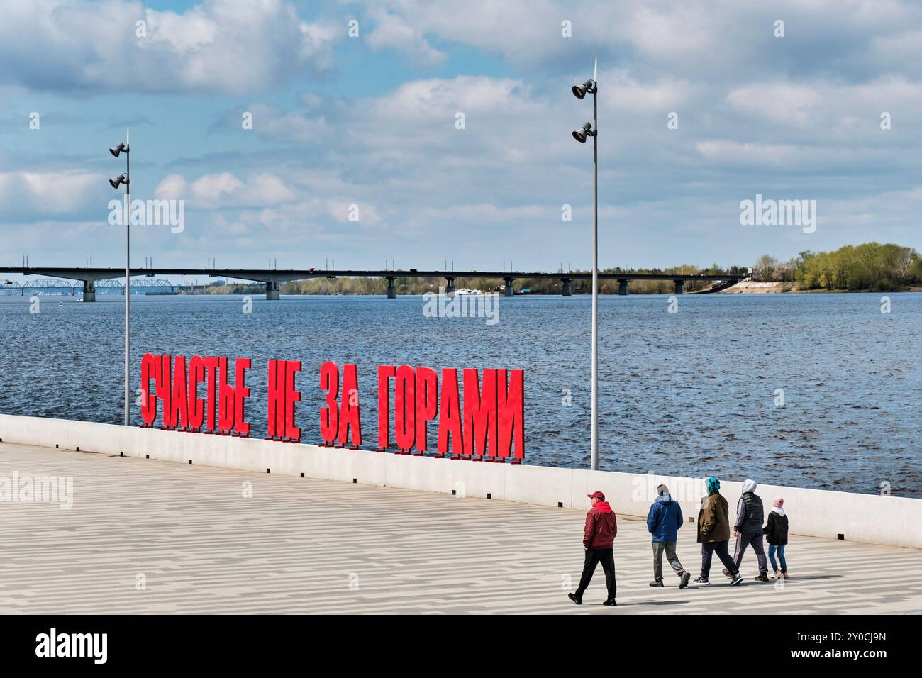 Perm, Russia - 18 maggio 2024: Gruppo di persone che camminano accanto a grandi lettere rosse russe sul lungofiume Kama. Text -la felicità non è lontana AW Foto Stock