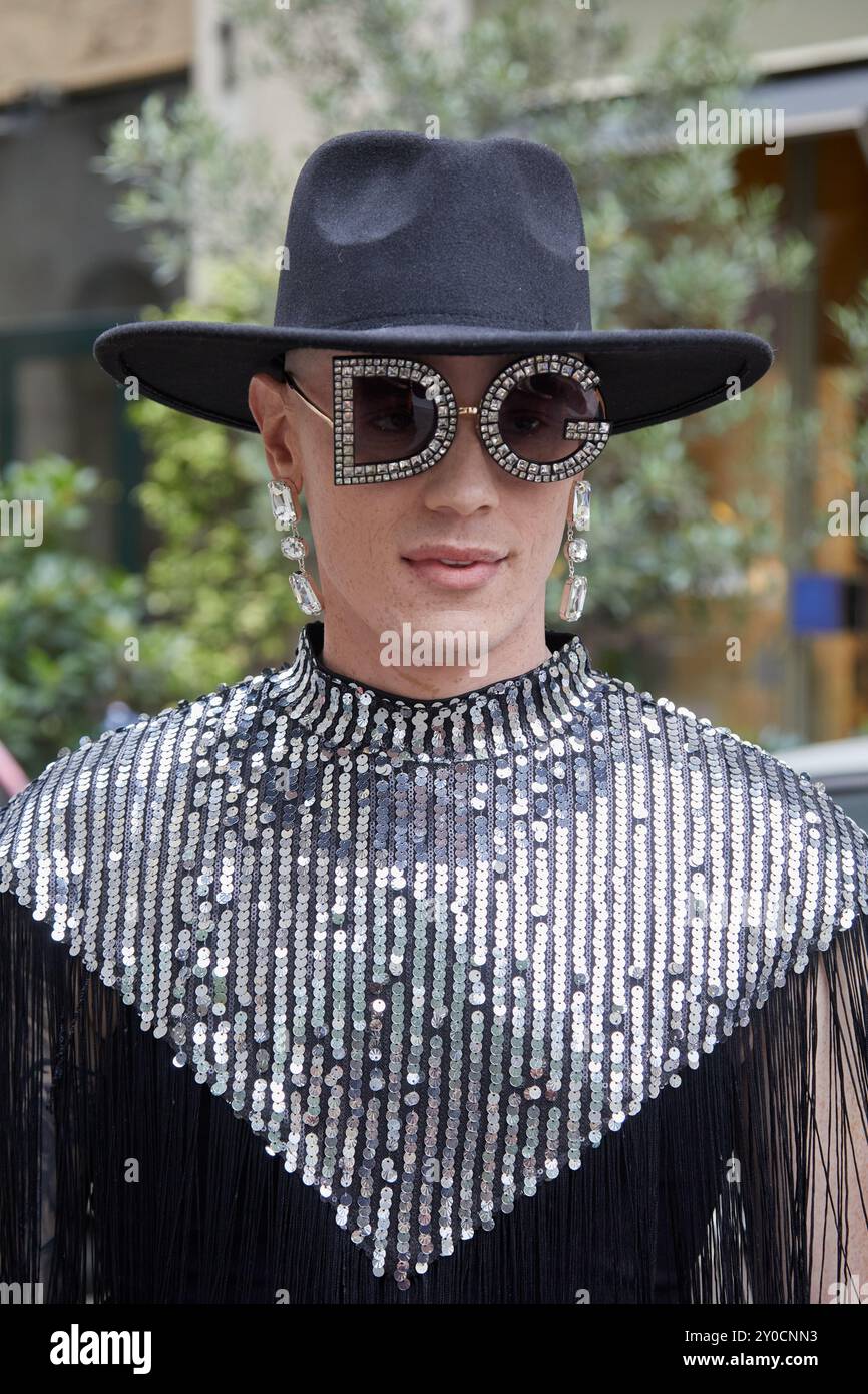 MILANO, ITALIA - 15 GIUGNO 2024: Uomo con occhiali da sole, cappello nero e camicia argentata in paillettes prima della sfilata di Dolce e Gabbana, Milano Fashion Week Street Foto Stock
