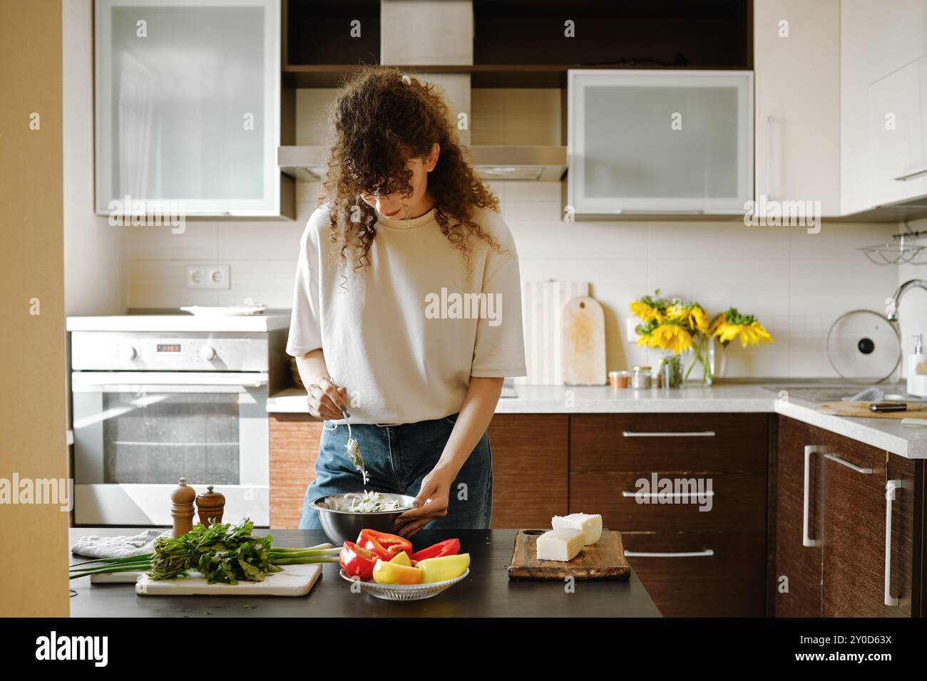 La donna prepara il ripieno per i peperoni in una ciotola in cucina Foto Stock