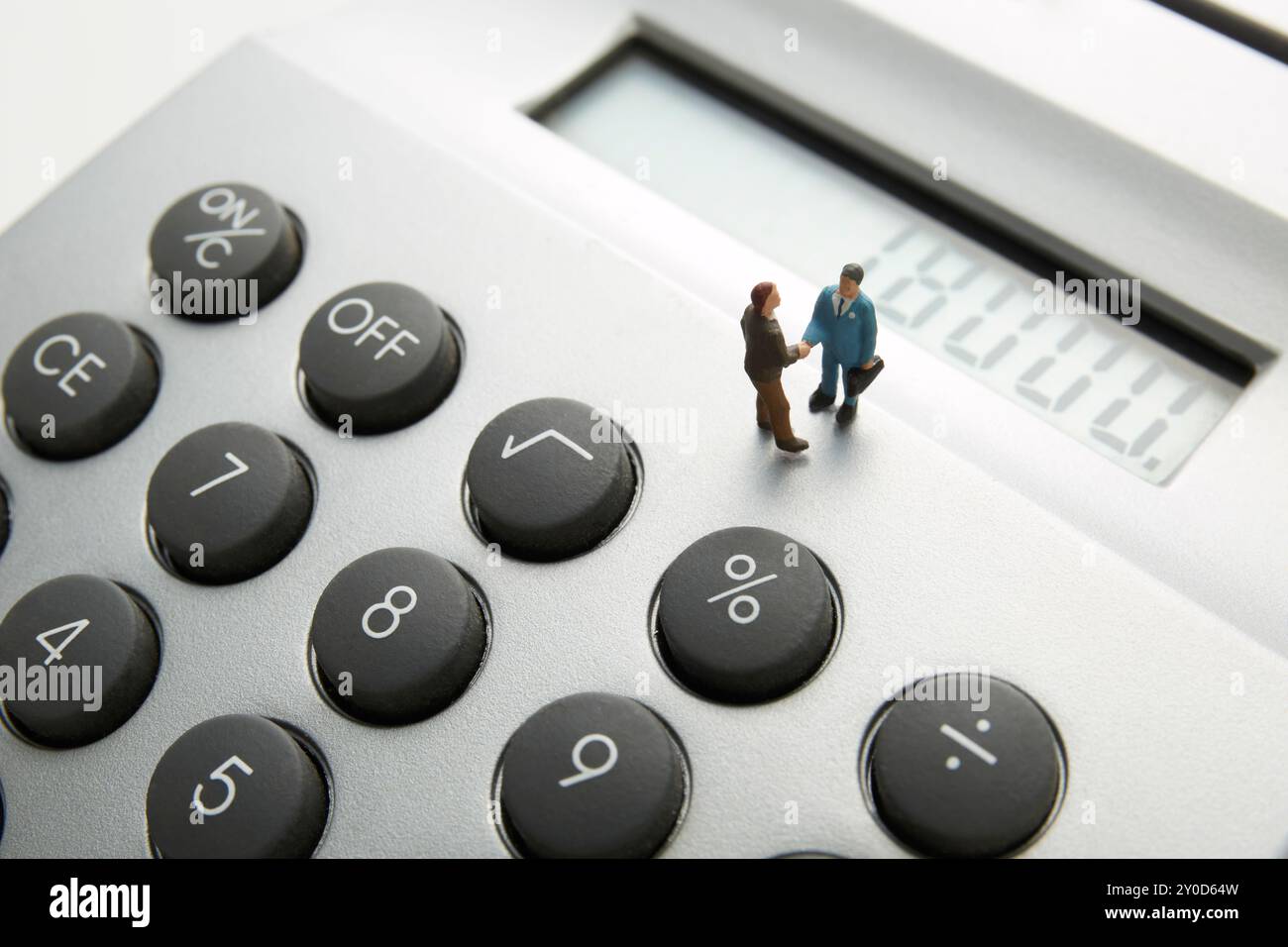 Bambole che scuotono la mano sopra una calcolatrice elettrica Foto Stock