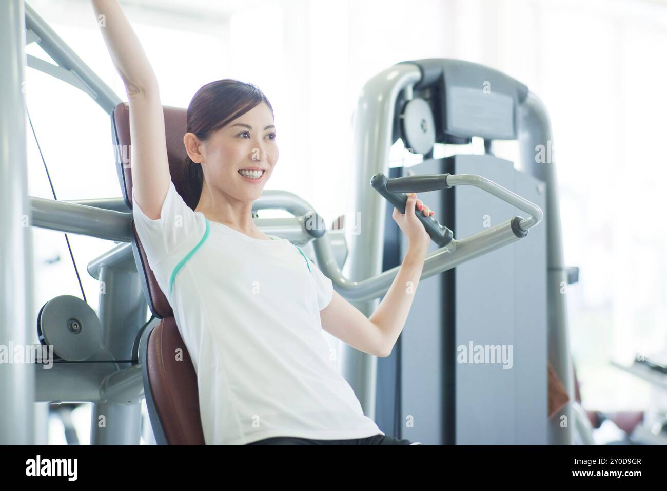 Una donna che si allena in palestra con un sorriso sul viso Foto Stock