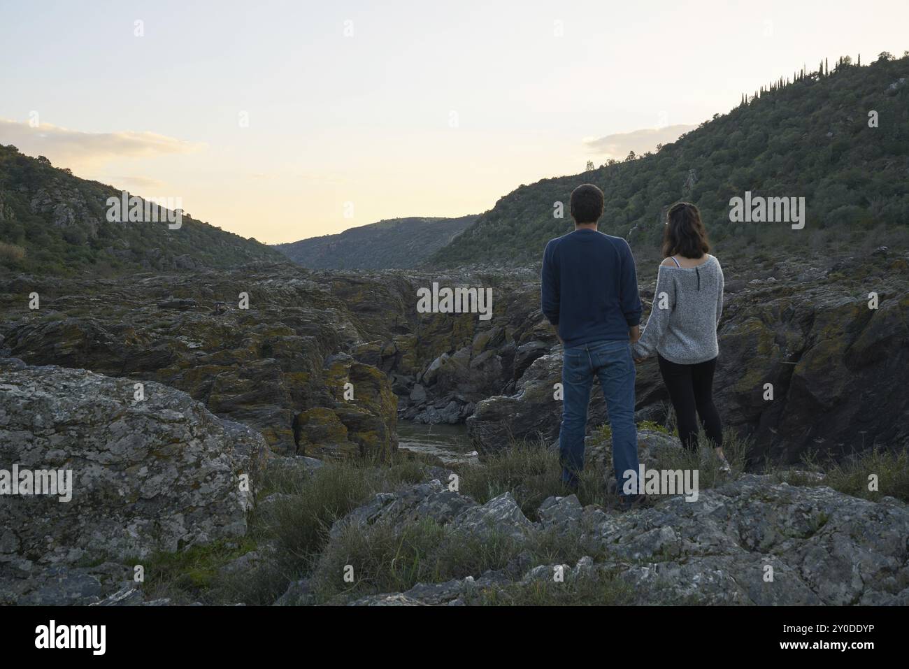 Coppia che guarda tenersi per mano la cascata di Pulo do Lobo con il fiume guadiana e dettagli rupestri al tramonto a Mertola Alentejo, Portogallo, Europa Foto Stock