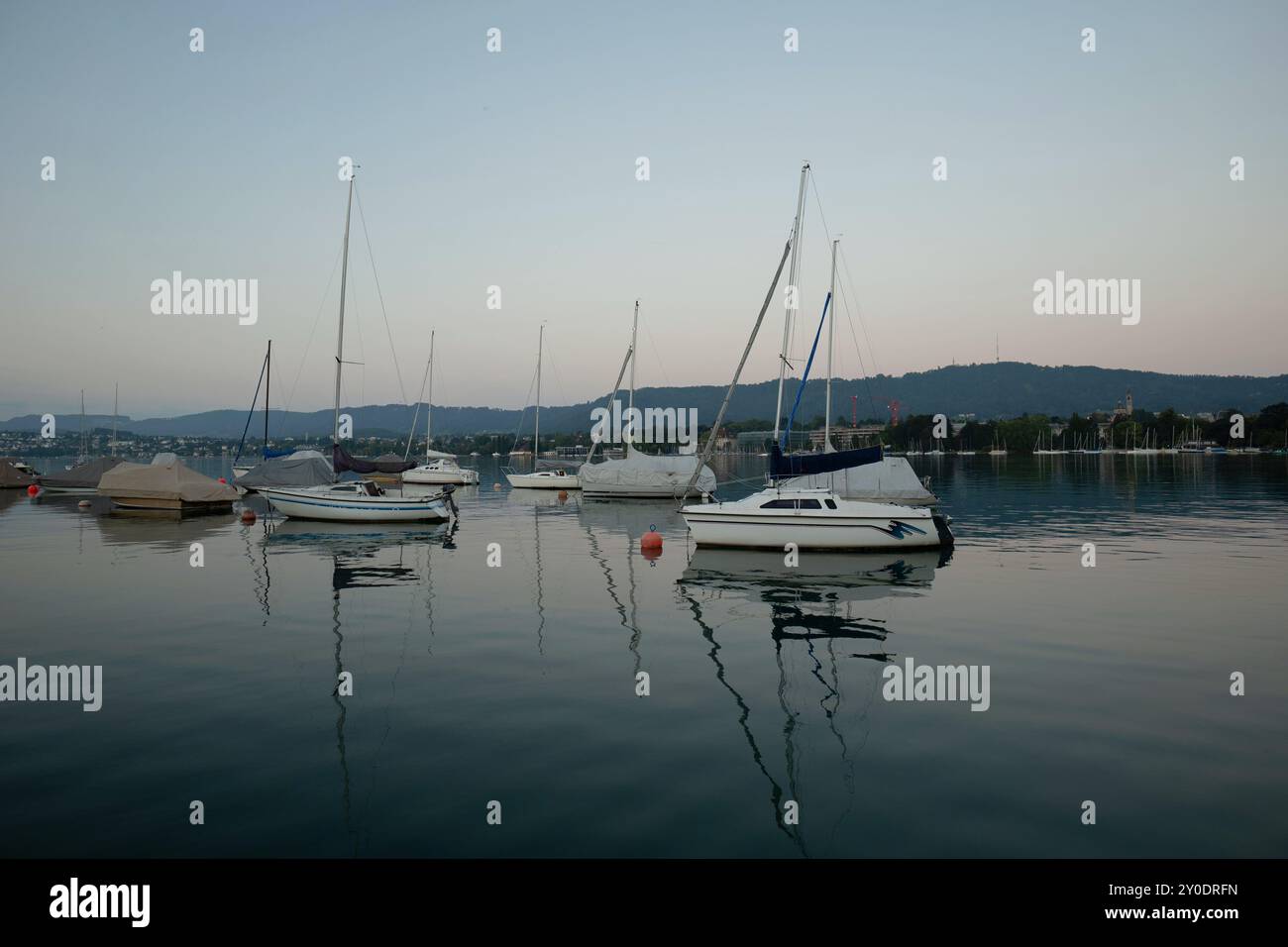 Piccole barche su un lago in Europa. Luce mattutina estiva moodia, niente nuvole, niente gente. Foto Stock
