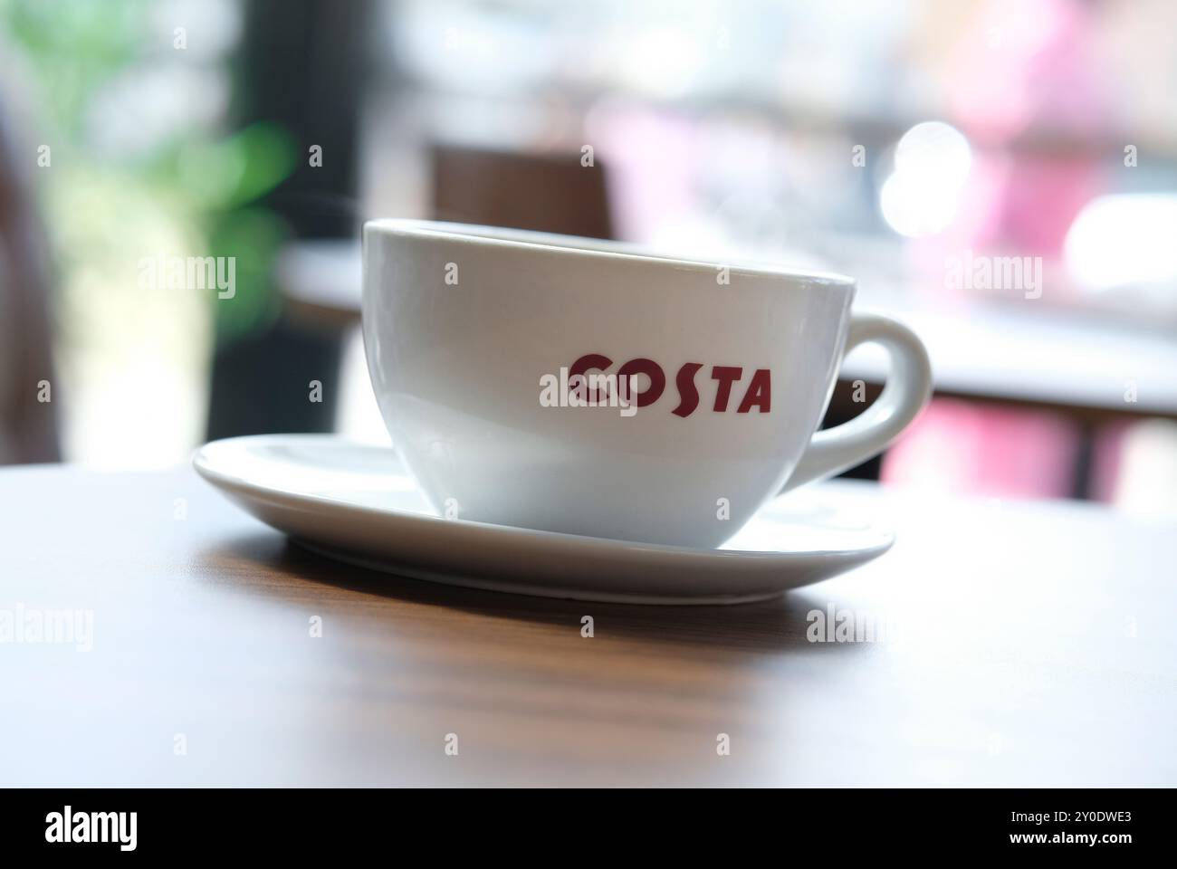 tazza di caffè costa e piattino su sfondo sfocato Foto Stock