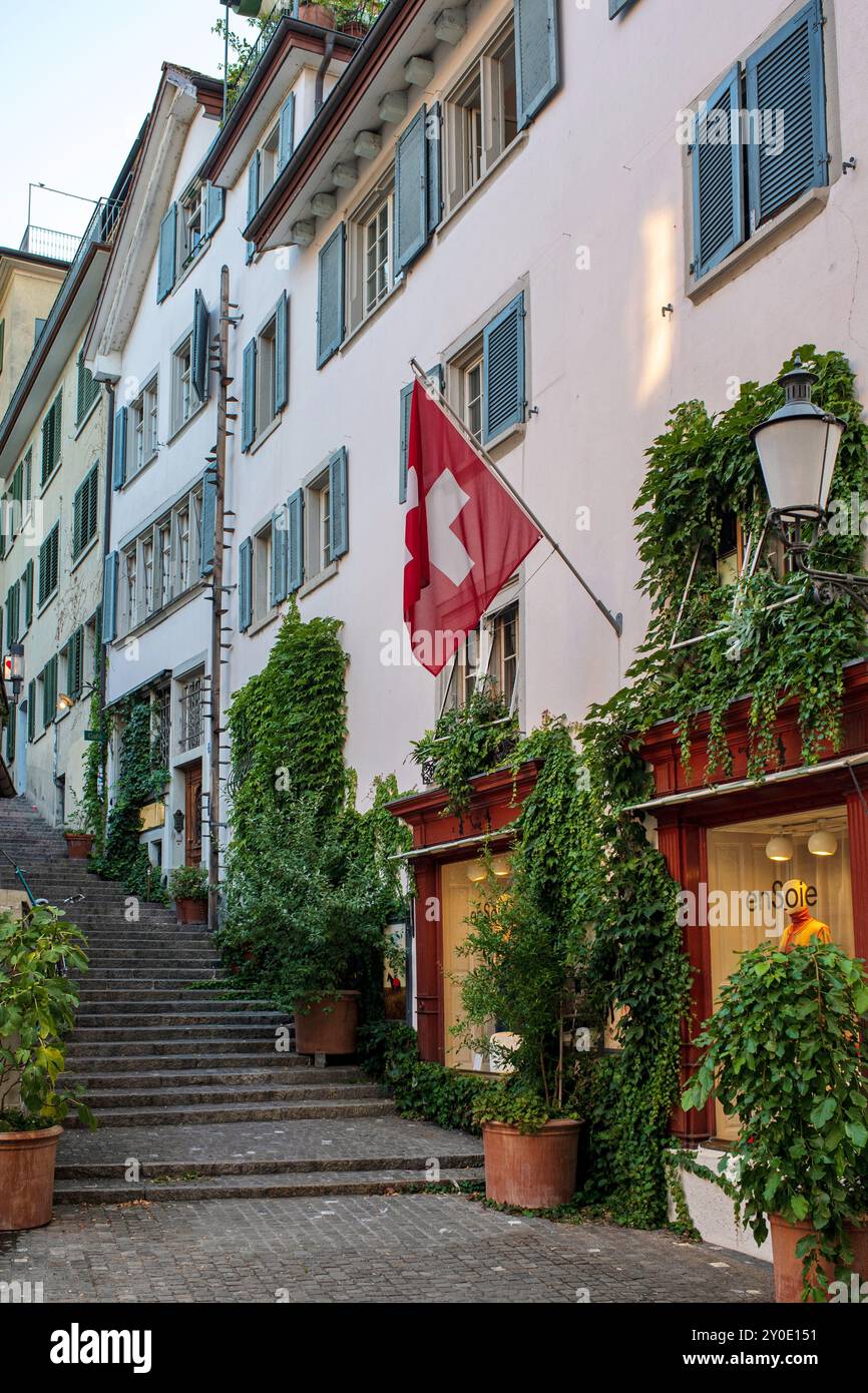 28-08-2024 Zurigo, Svizzera. Piccoli negozi su una strada stretta con scale in pietra che conducono al famoso punto panoramico di Lindenhof. Soleggiato giorno d'estate, niente fastidio Foto Stock