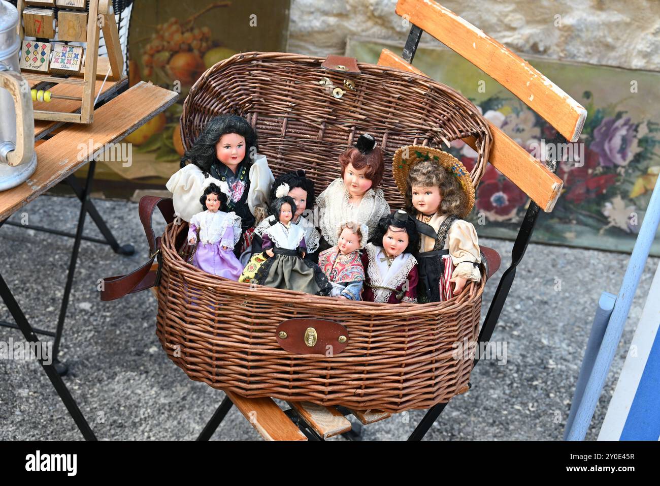 Bambole vintage, collezionabili, collezionabili o antiche in costume provenzale in mostra in un cesto di vimini vecchio in un Brocante o al mercato dei collezionisti in Francia Foto Stock