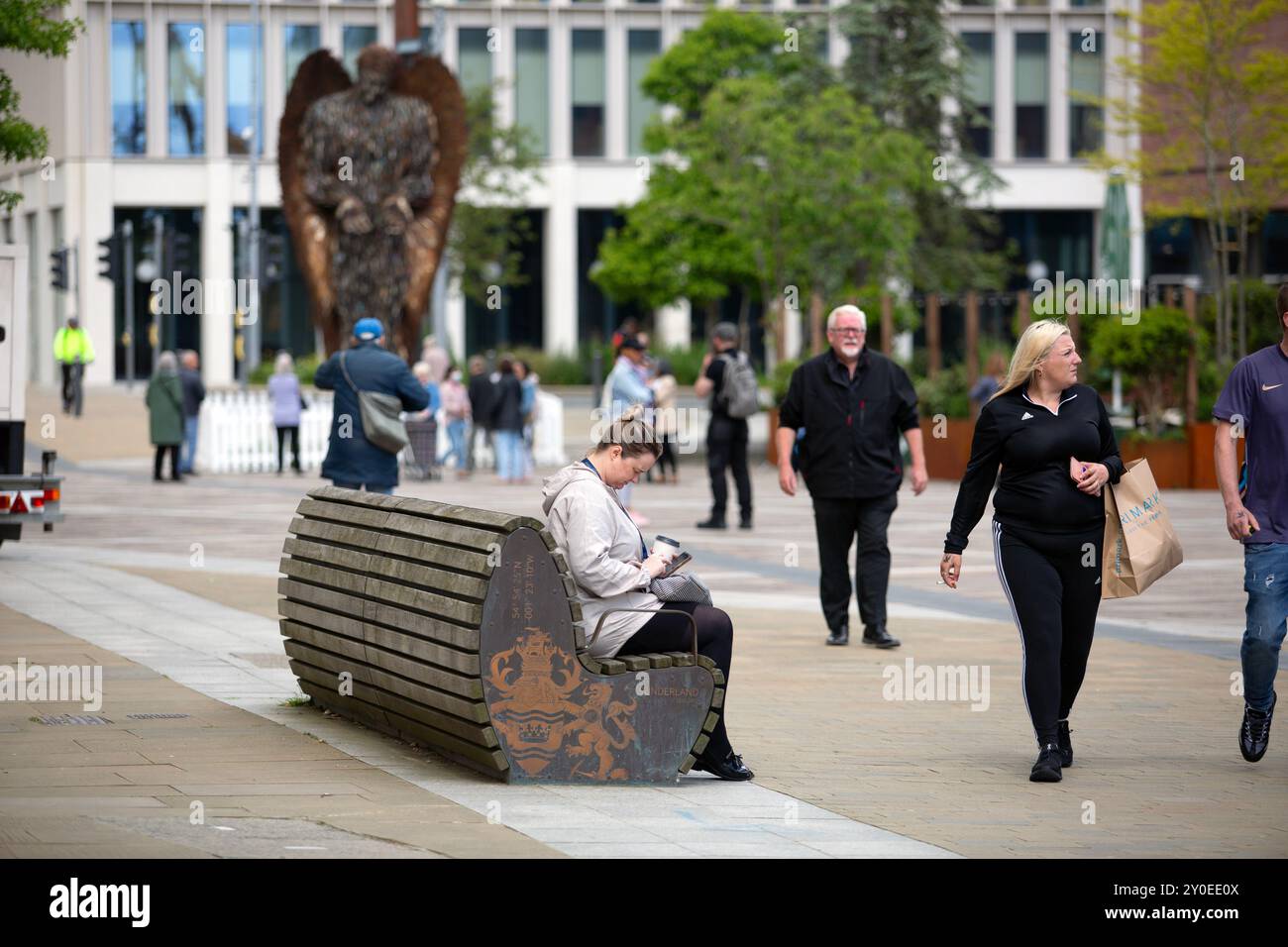 Una donna siede in Keel Square nel centro di Sunderland City, dove l'area Riverside della città viene trasformata mentre la città di Sunderland subisce un Foto Stock