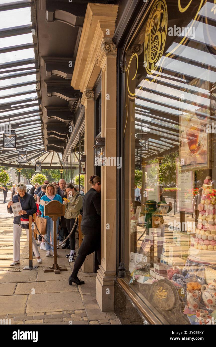 Persone in coda fuori dalle sale da tè di Betty, Harrogate, North Yorkshire, Inghilterra, Regno Unito Foto Stock