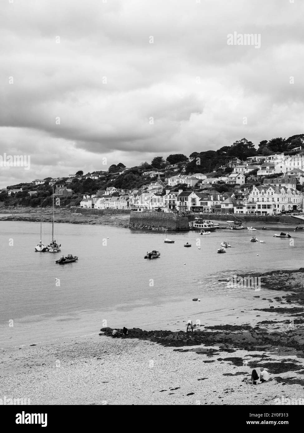 Bianco e nero, persone sedute a St Mawes Beach, St Mawes, Falmouth, Cornovaglia, Inghilterra, REGNO UNITO, REGNO UNITO. Foto Stock