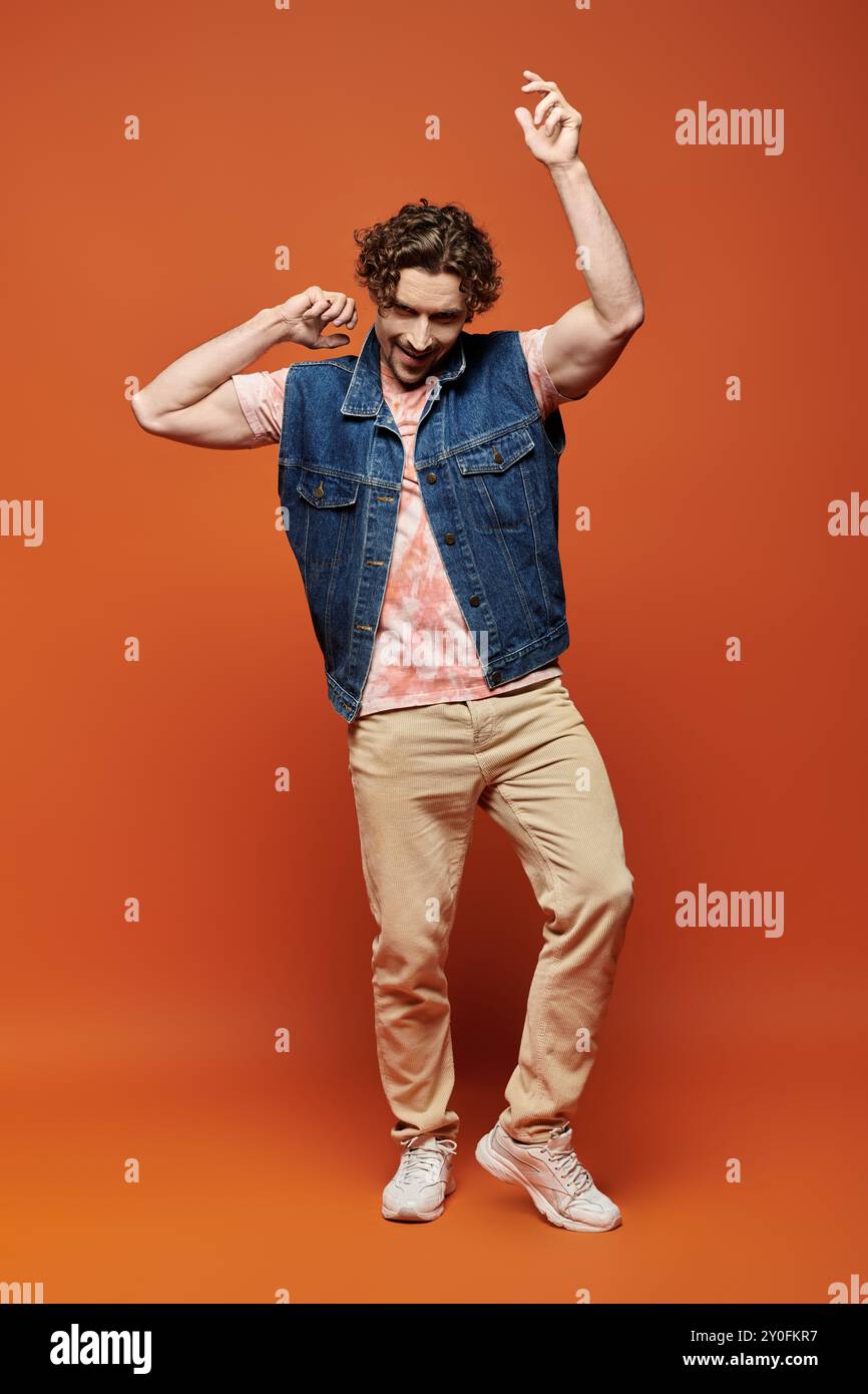 Un uomo elegante danzerà con energia vibrante in un ambiente colorato. Foto Stock