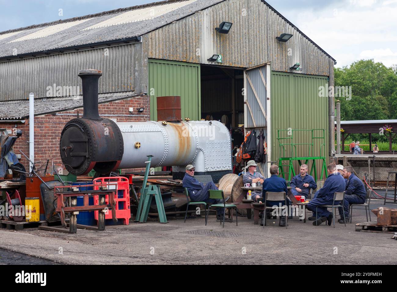 I volontari si prendono una pausa dal lavoro per ricostruire una vecchia locomotiva a vapore, che si pensa sia Stroudley E1 No W2 "Yarmouth": Havenstreet, Isola di Wight, Regno Unito Foto Stock