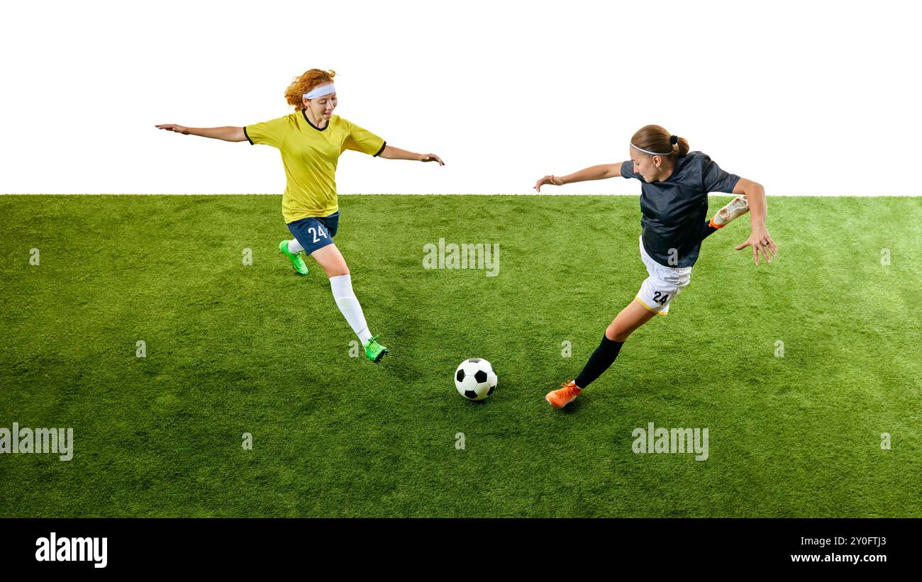 Due giovani donne, giocatori di calcio intensi, in volo e in azione sul green Field, che cercano di superare l'altra per controllare il pallone. Foto Stock