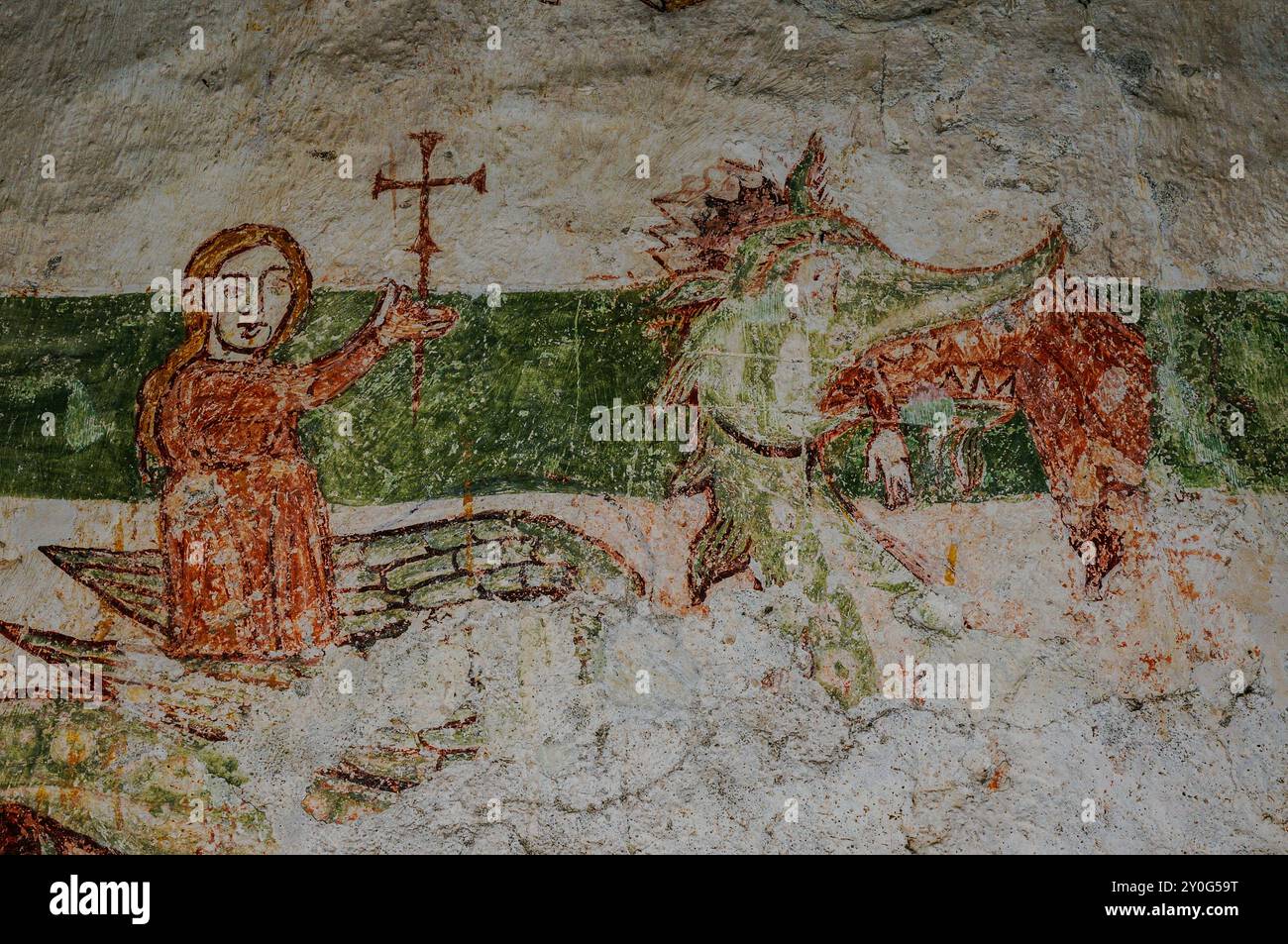Santa Margherita d'Antiochia si erge in trionfo su un drago. Particolare dell'affresco medievale, Abbazia di Piona, Colico, Lombardia, Italia. Secondo la tradizione, il drago era Satana sotto mentite spoglie e rigurgitò Margaret viva quando la sua croce irritò le interiora del mostro. Questo affresco raffigura sia Margaret che viene lanciata fuori dalla bocca del drago e in piedi vittoriosa, la sua croce tenuta in alto. Foto Stock