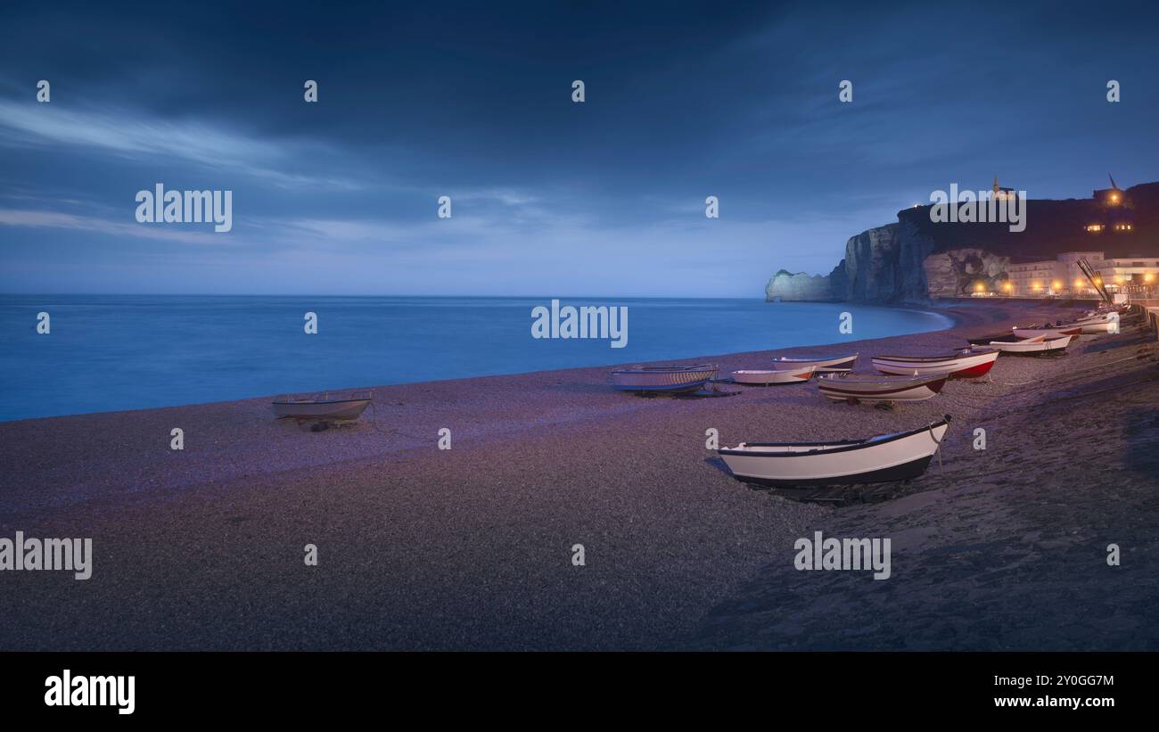 Ora blu sulle barche e sulla spiaggia di Etretat in una serata nebbiosa. Vista panoramica. Regione della Normandia, Francia, Europa. Foto Stock