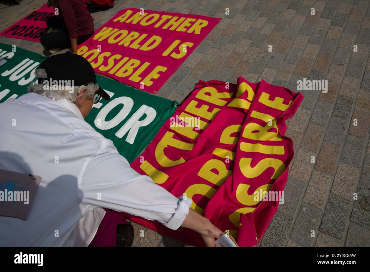 Windsor, Regno Unito, 1 settembre 2024. Un dimostratore stende uno striscione di protesta sul pavimento. I membri della Extinction Rebellion tengono una dimostrazione di tre giorni fuori dal castello di Windsor. Il gruppo chiede al nuovo governo laburista di istituire un'assemblea dei cittadini per affrontare il cambiamento climatico. Crediti: James Willoughby/Alamy Live News Foto Stock