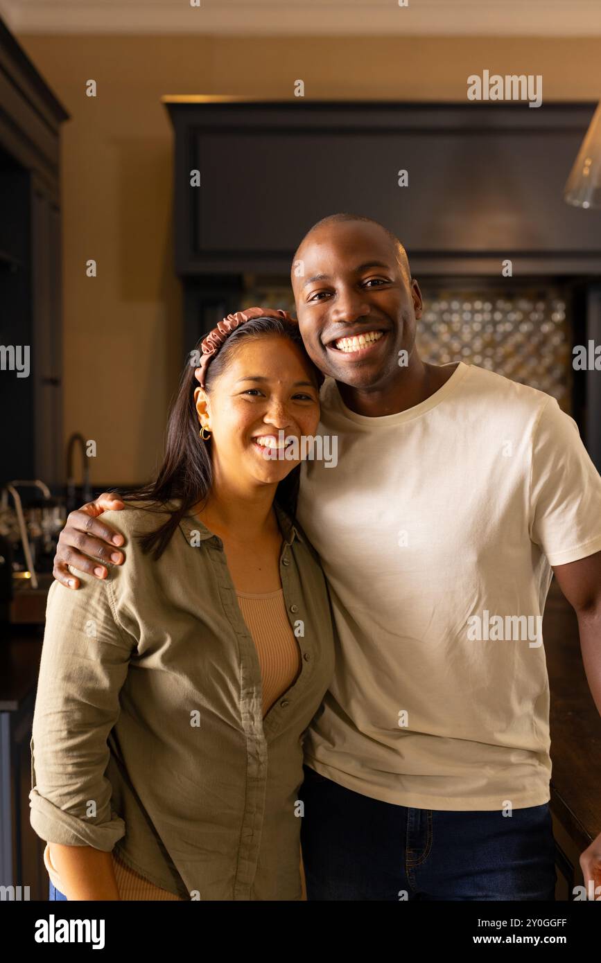 Coppia multirazziale sorridente in piedi insieme in cucina, godendosi il tempo a casa Foto Stock