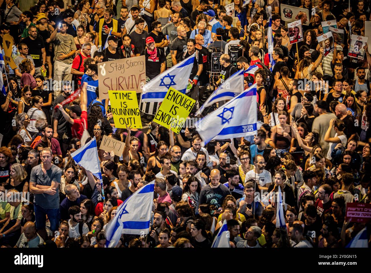 I manifestanti reggono cartelli e sventolano la bandiera israeliana durante la manifestazione. Gli organizzatori sostengono che oltre 700.000 israeliani sono saliti nelle strade delle città di tutto il paese domenica sera un giorno dopo che i corpi di Carmel Gat, Eden Yerushalmi, Hersh Goldberg-Polin, Alexander Lobanov, Almog Sarusi e il Maestro Ori Danino, sono stati salvati da Gaza. I manifestanti chiesero che il primo ministro Benjamin Netanyahu raggiungesse un accordo di cessate il fuoco con Hamas per riportare a casa i prigionieri rimasti. (Foto di Eyal Warshavsky/SOPA Images/Sipa USA) Foto Stock