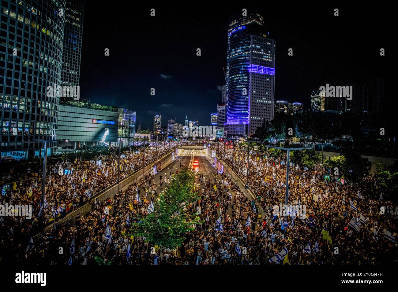 I manifestanti reggono cartelli e sventolano la bandiera israeliana durante la manifestazione. Gli organizzatori sostengono che oltre 700.000 israeliani sono saliti nelle strade delle città di tutto il paese domenica sera un giorno dopo che i corpi di Carmel Gat, Eden Yerushalmi, Hersh Goldberg-Polin, Alexander Lobanov, Almog Sarusi e il Maestro Ori Danino, sono stati salvati da Gaza. I manifestanti chiesero che il primo ministro Benjamin Netanyahu raggiungesse un accordo di cessate il fuoco con Hamas per riportare a casa i prigionieri rimasti. (Foto di Eyal Warshavsky/SOPA Images/Sipa USA) Foto Stock