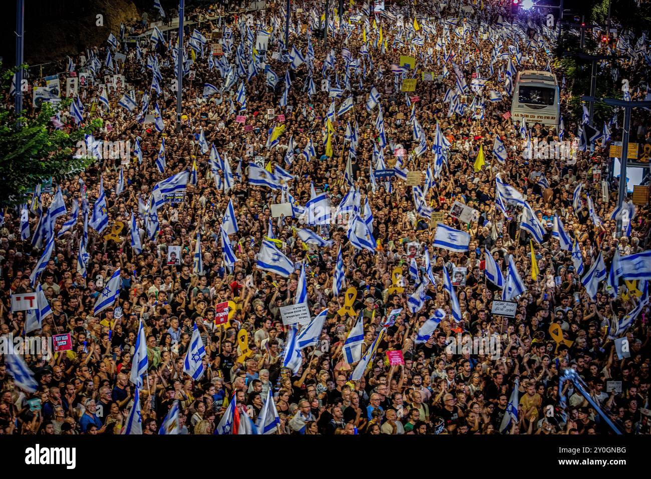 I manifestanti reggono cartelli e sventolano la bandiera israeliana durante la manifestazione. Gli organizzatori sostengono che oltre 700.000 israeliani sono saliti nelle strade delle città di tutto il paese domenica sera un giorno dopo che i corpi di Carmel Gat, Eden Yerushalmi, Hersh Goldberg-Polin, Alexander Lobanov, Almog Sarusi e il Maestro Ori Danino, sono stati salvati da Gaza. I manifestanti chiesero che il primo ministro Benjamin Netanyahu raggiungesse un accordo di cessate il fuoco con Hamas per riportare a casa i prigionieri rimasti. (Foto di Eyal Warshavsky/SOPA Images/Sipa USA) Foto Stock