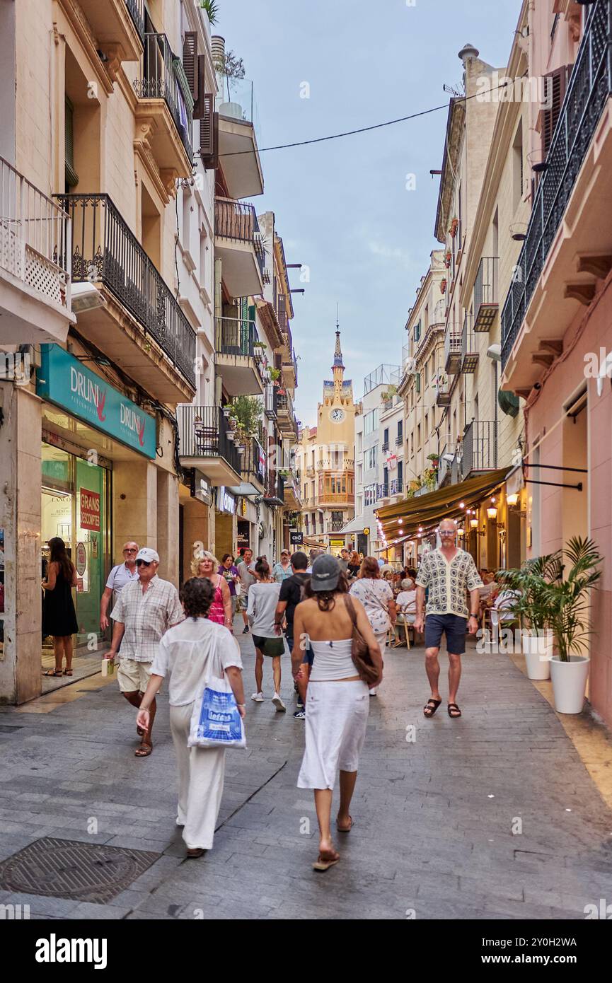 Sitges, Barcellona - 01 settembre 2024: Il mix di turisti e locali in questa strada di Sitges crea un'atmosfera vibrante e accogliente. Foto Stock