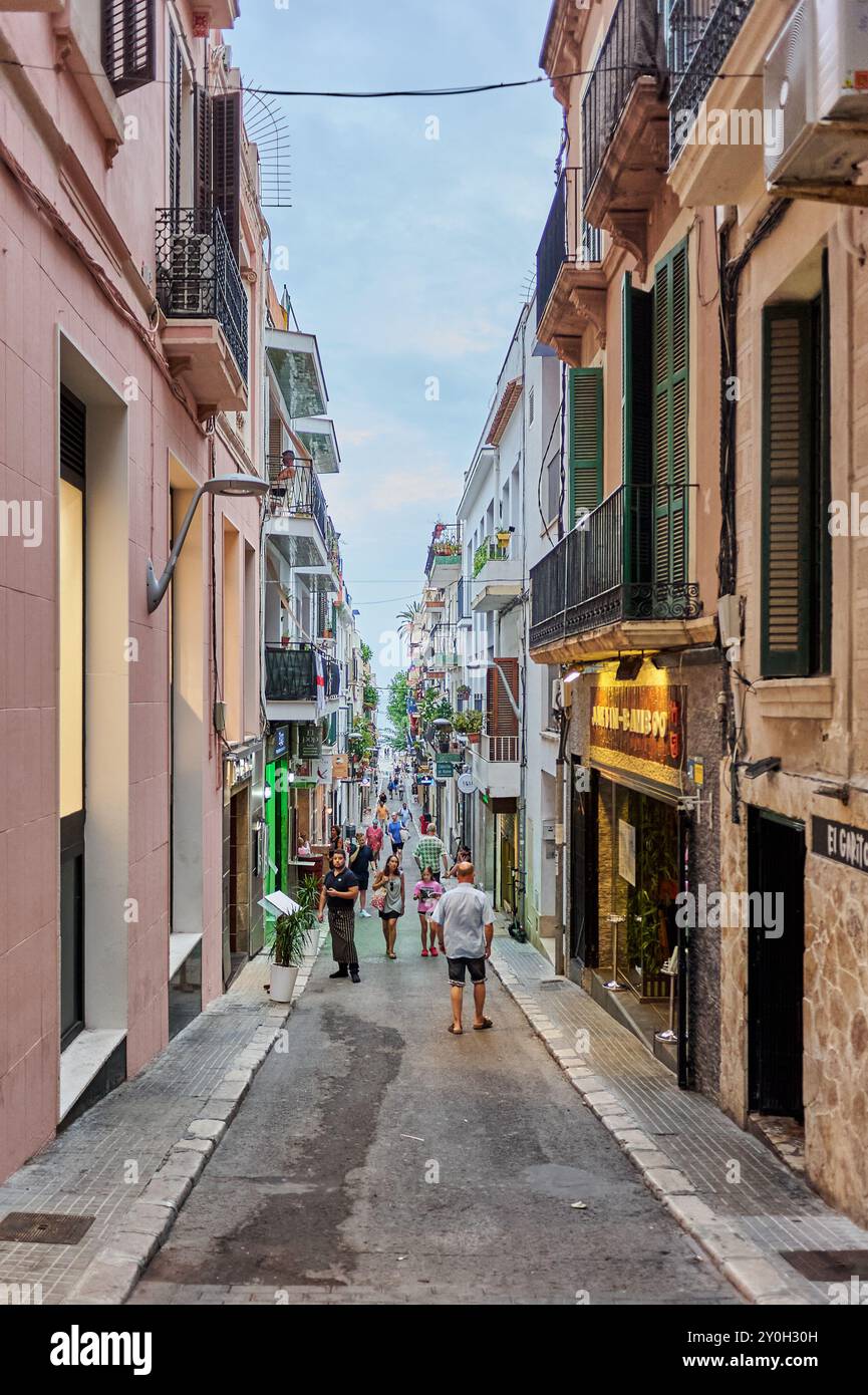 Sitges, Barcellona - 01 settembre 2024: La strada di Sitges, piena di vita e di colori, è un perfetto riflesso del fascino mediterraneo. Foto Stock