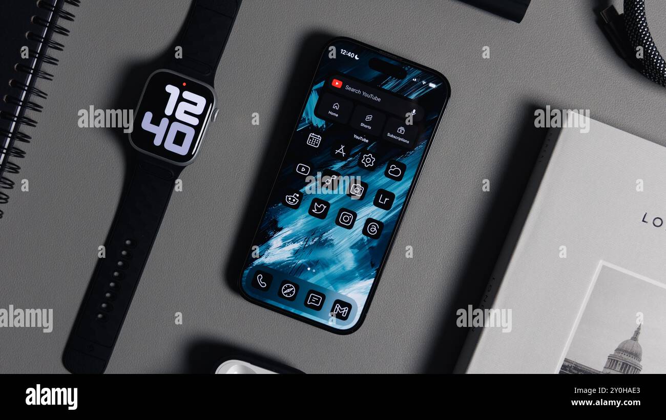 LONDRA - 28 AGOSTO 2024: Apple Watch con cinturino nero e iPhone sullo sfondo della scrivania Foto Stock