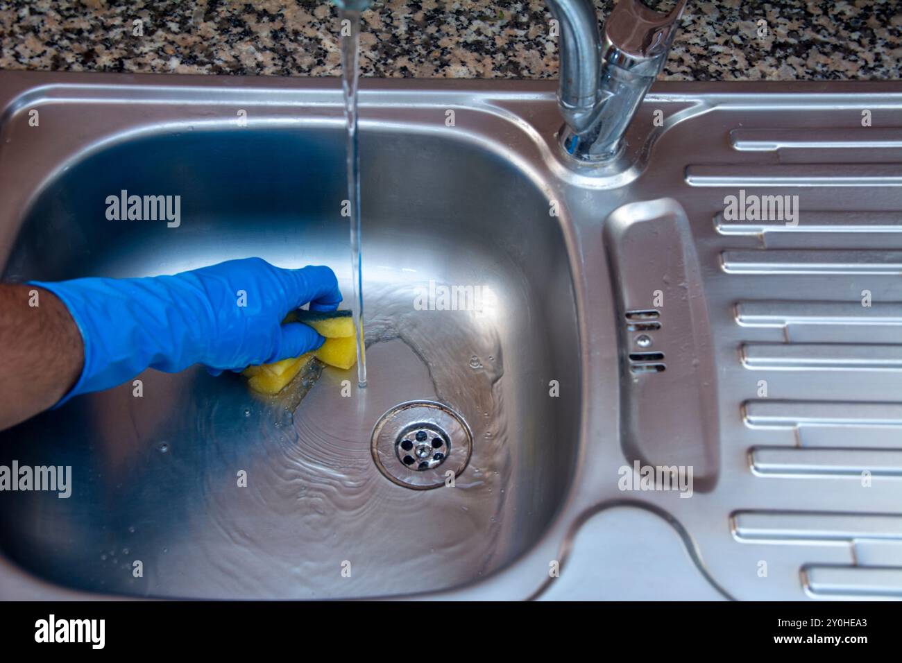 Pulire il lavandino sporco in cucina con acqua in primo piano Foto Stock