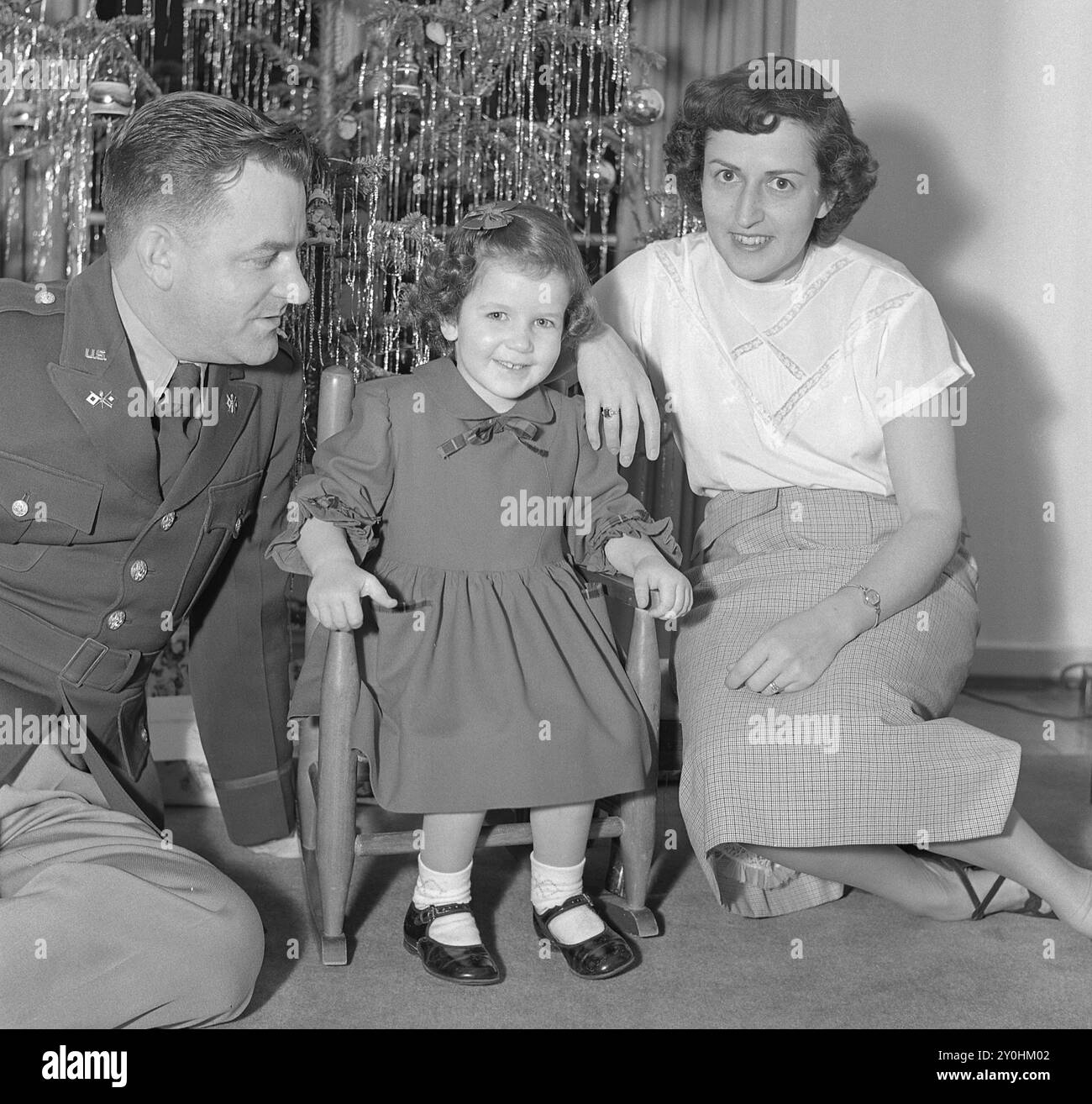 Foto natalizia vintage del 1950, ufficiale dell'esercito con moglie e piccola figlia davanti all'albero di Natale Foto Stock