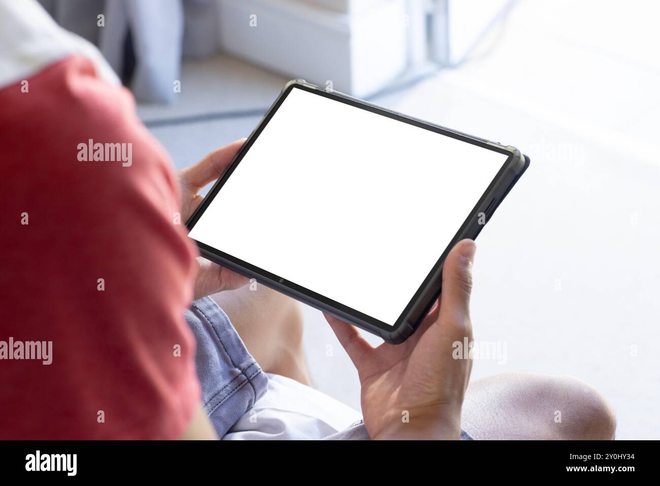 Tenere il tablet con schermo vuoto, la persona seduta e sfogliare i contenuti, copiare lo spazio Foto Stock