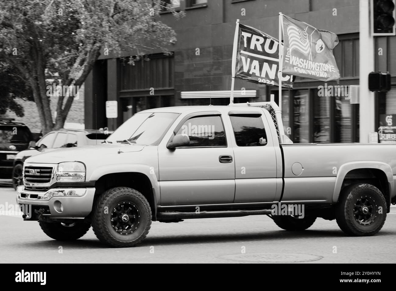 Un pick-up GMC di dimensioni standard che vola con le bandiere di Donald Trump e MAGA. Ellensburg, Washington, Stati Uniti. Immagine in bianco e nero. Foto Stock