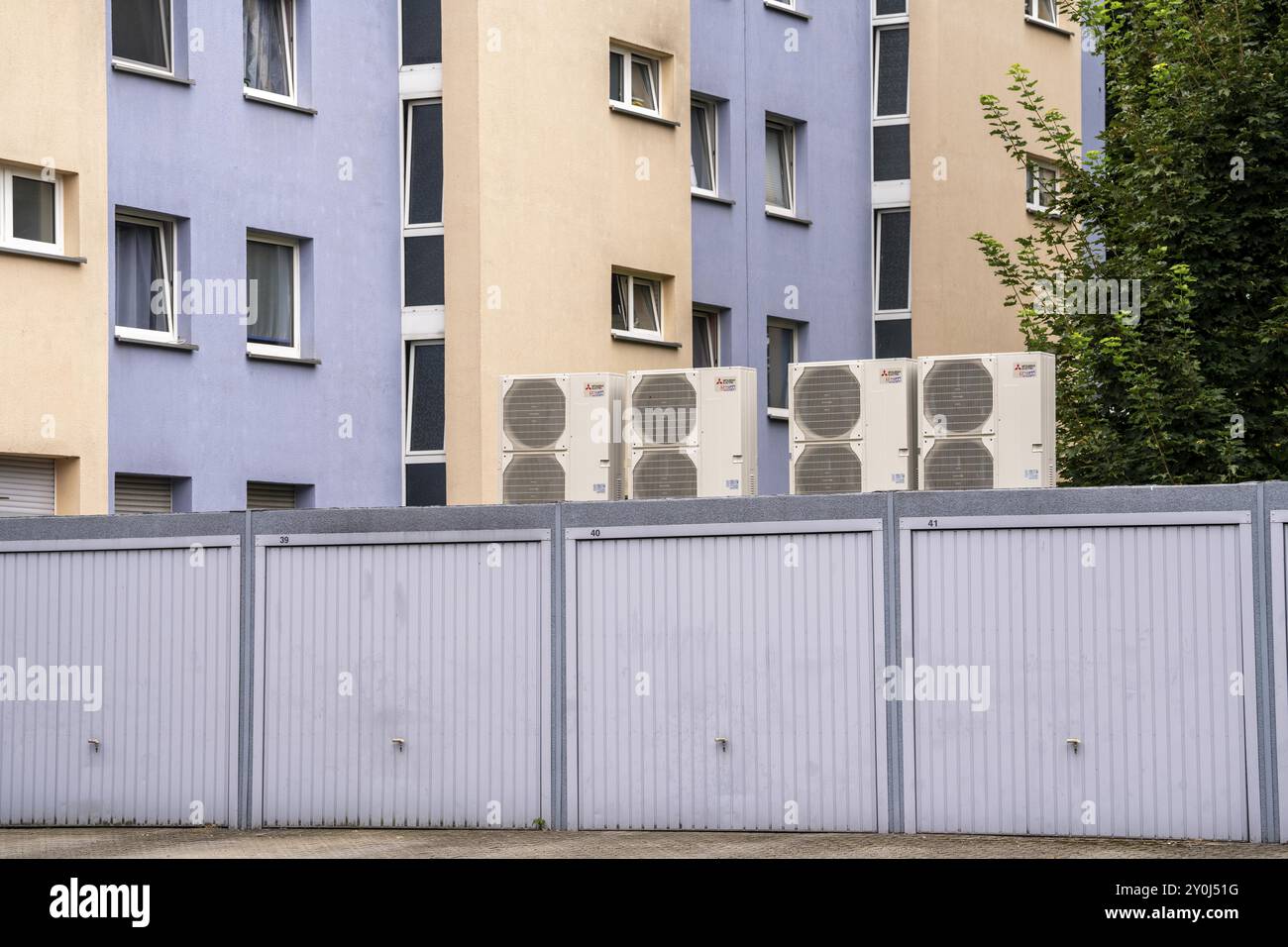 Le pompe di calore in un'area residenziale, le case multifamiliari sono dotate di riscaldamento, raffreddamento e acqua calda domestica tramite questi dispositivi, installati in garage Foto Stock