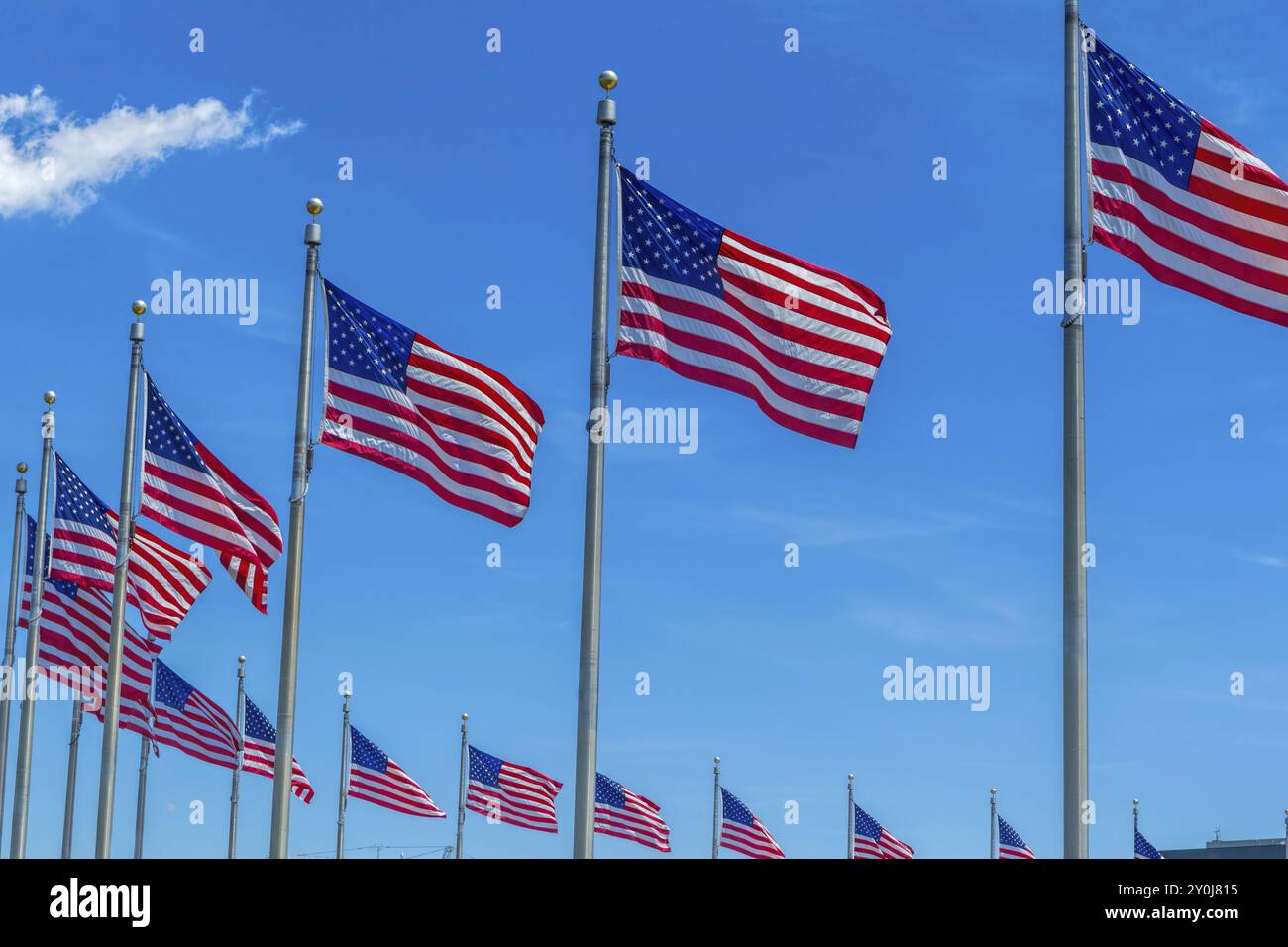 Bandiere americane sui pali di bandiera contro un'onda blu del cielo nel vento Foto Stock