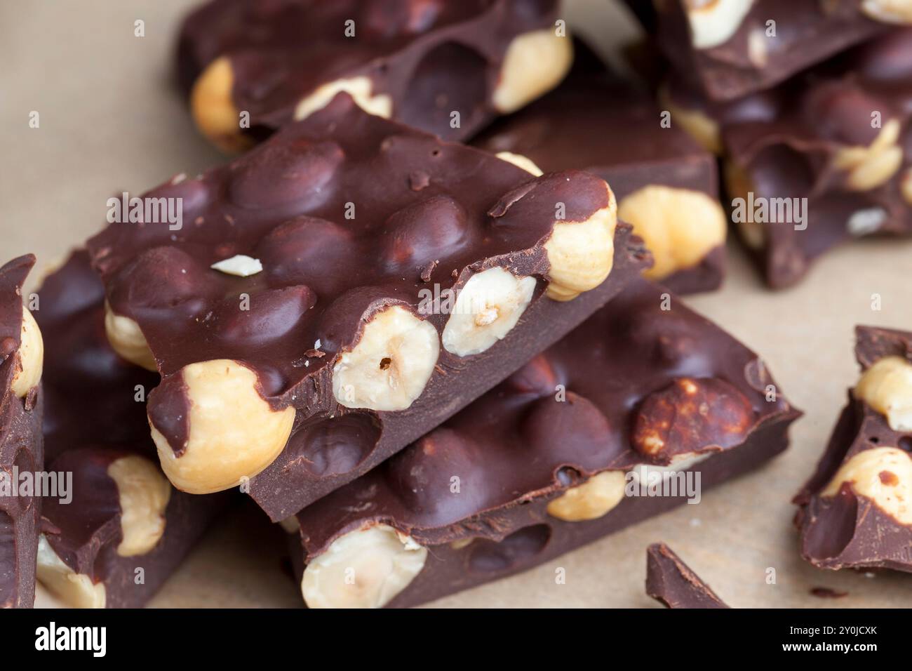 Pezzi di cioccolato al latte fatto in casa con un sacco di burro di cacao e nocciole, delizioso cioccolato fatto in casa con nocciole Foto Stock