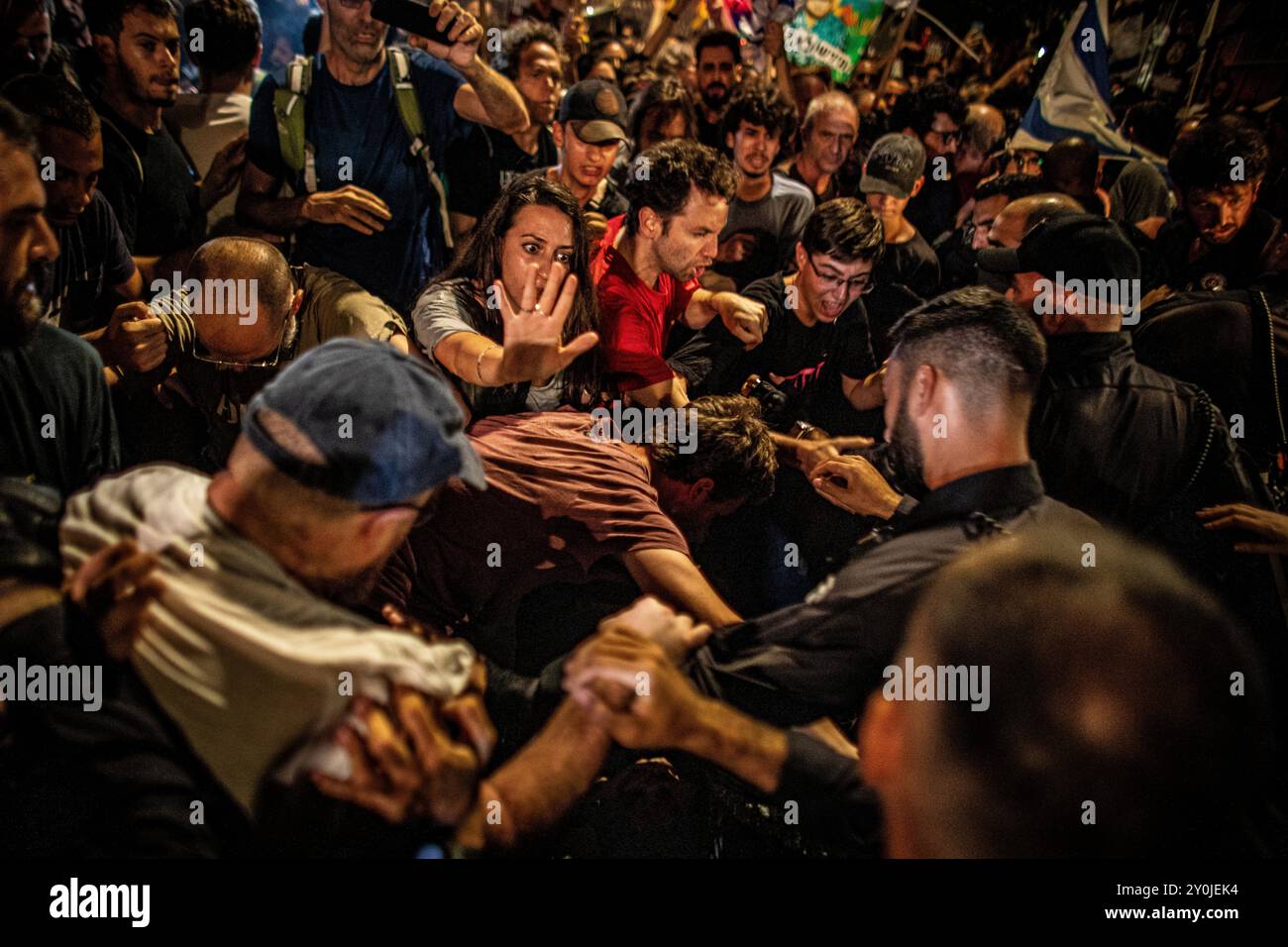 Un manifestante cerca di impedire agli agenti di polizia israeliani di spingere la folla durante una manifestazione a Gerusalemme dopo il funerale di Hersh Goldberg Polin lunedì, 2 settembre 2024. Decine di migliaia di persone si sono riunite in Israele per un secondo giorno dopo che i corpi di Carmel Gat, Eden Yerushalmi, Hersh Goldberg-Polin, Alexander Lobanov, Almog Sarusi e il Maestro Ori Danino sono stati salvati da Gaza. I manifestanti stanno chiedendo al primo ministro Benjamin Netanyahu e al suo governo di raggiungere un accordo per garantire il rilascio dei restanti ostaggi presi da Hamas durante gli attacchi del 7 ottobre. Foto di Eyal Warshavsky. Foto Stock