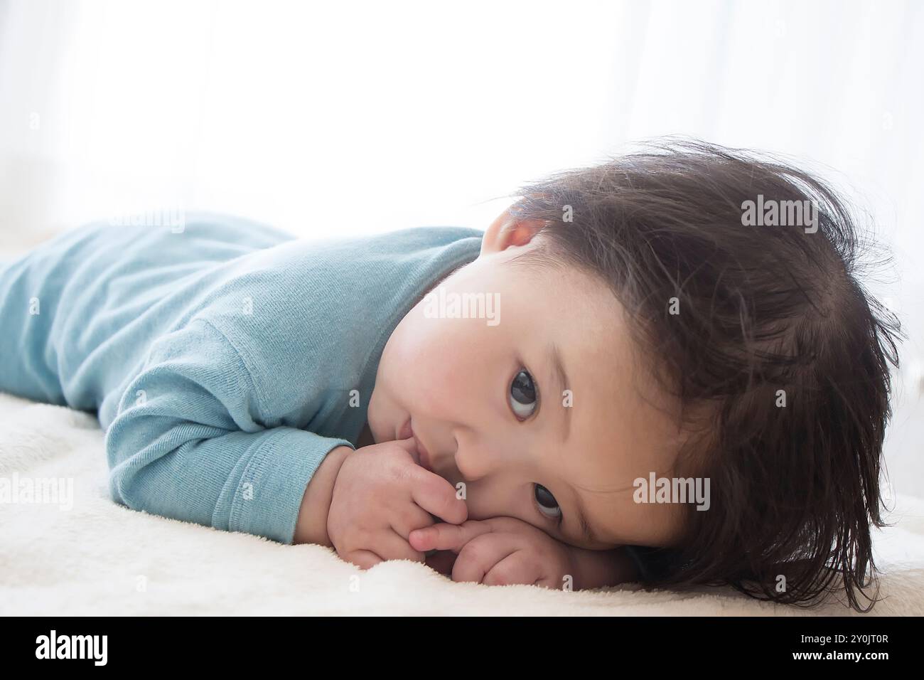 Stendendo il bambino con un dito in bocca Foto Stock