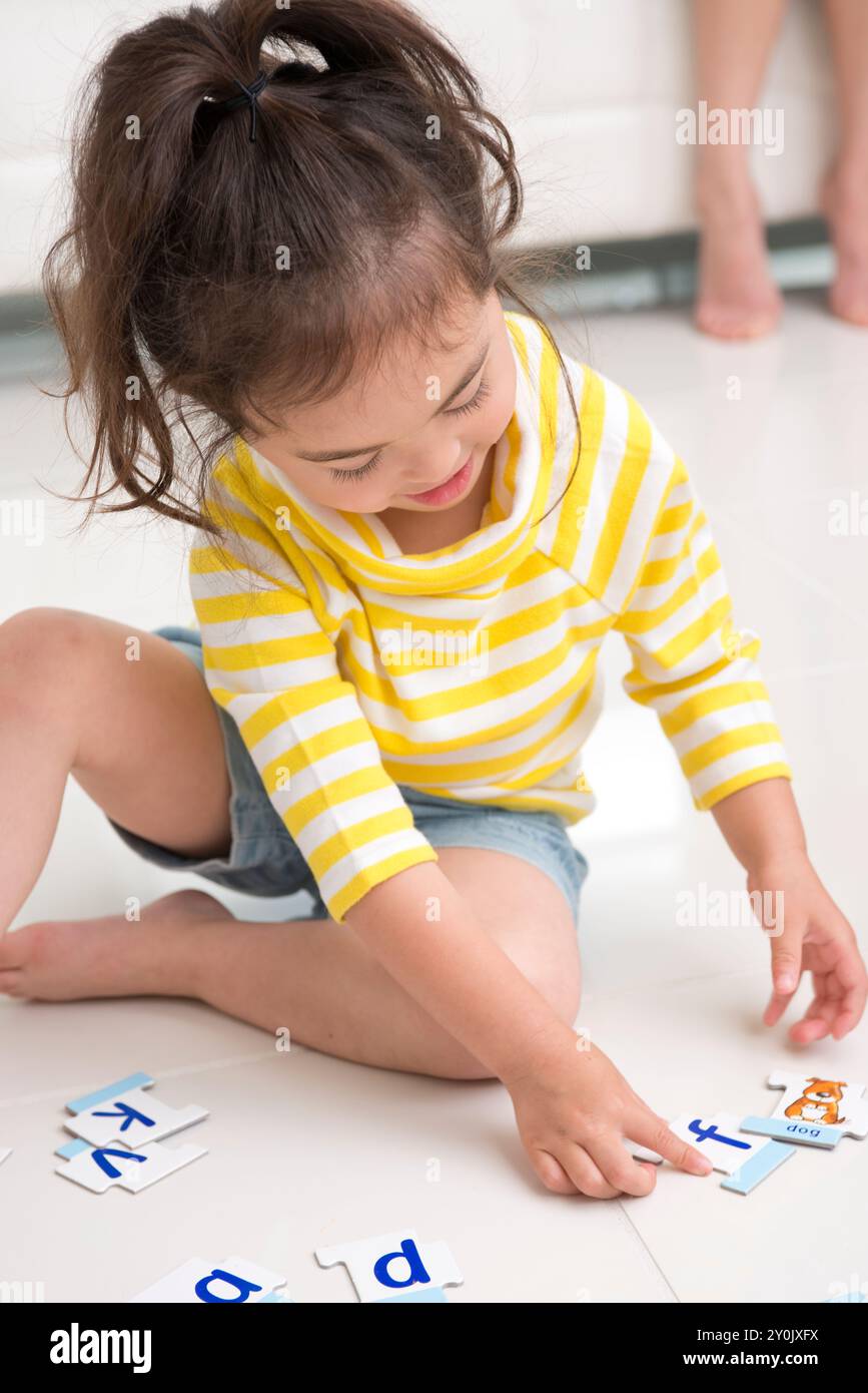 Ragazza che gioca con il materiale per l'insegnamento dell'inglese Foto Stock