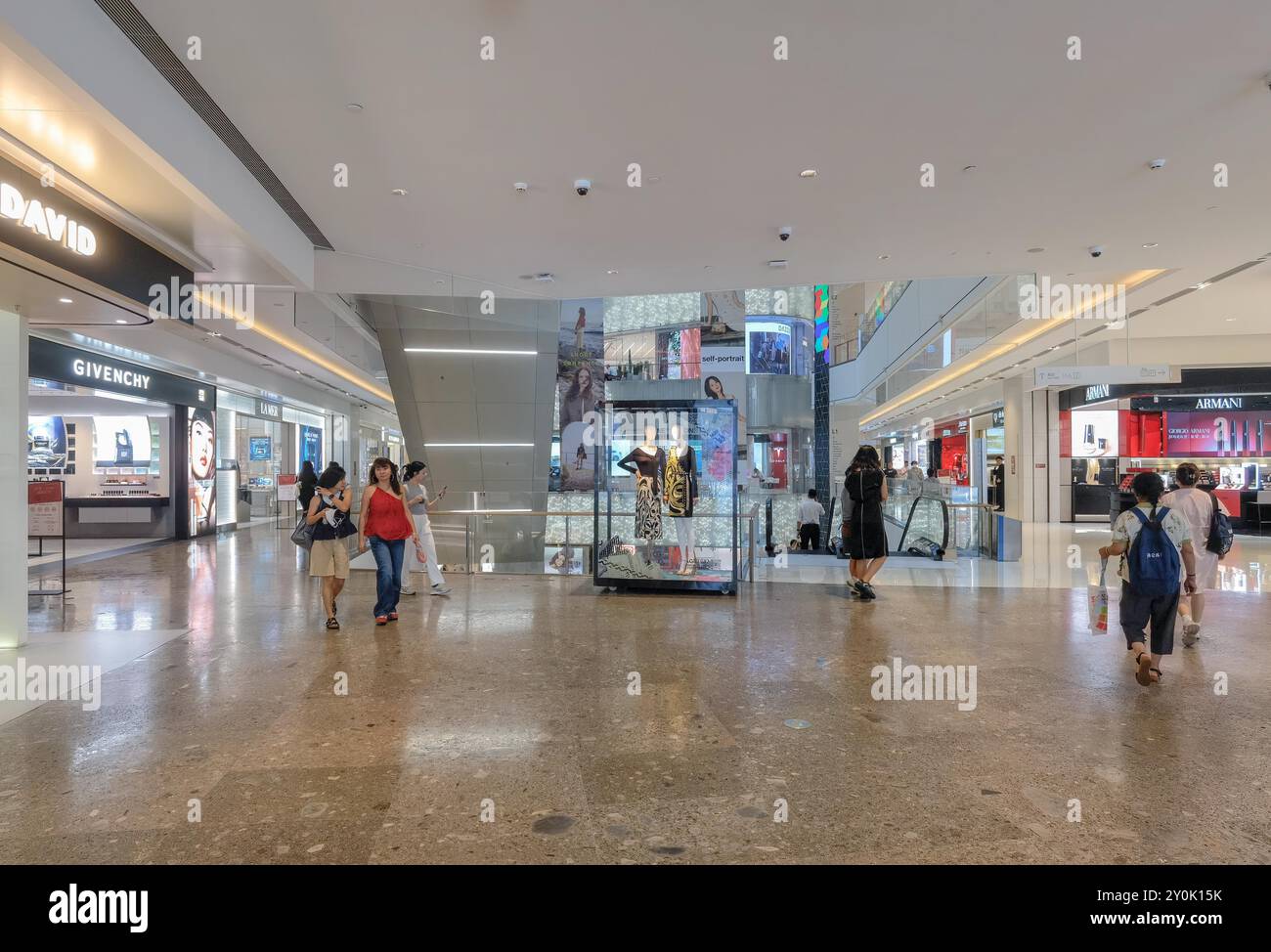 Shenzhen, Cina - 2 settembre 2024: Interno Di Un centro commerciale con pavimento in marmo, scala mobile e persone che camminano. La vetrina per una crusca di lusso Foto Stock