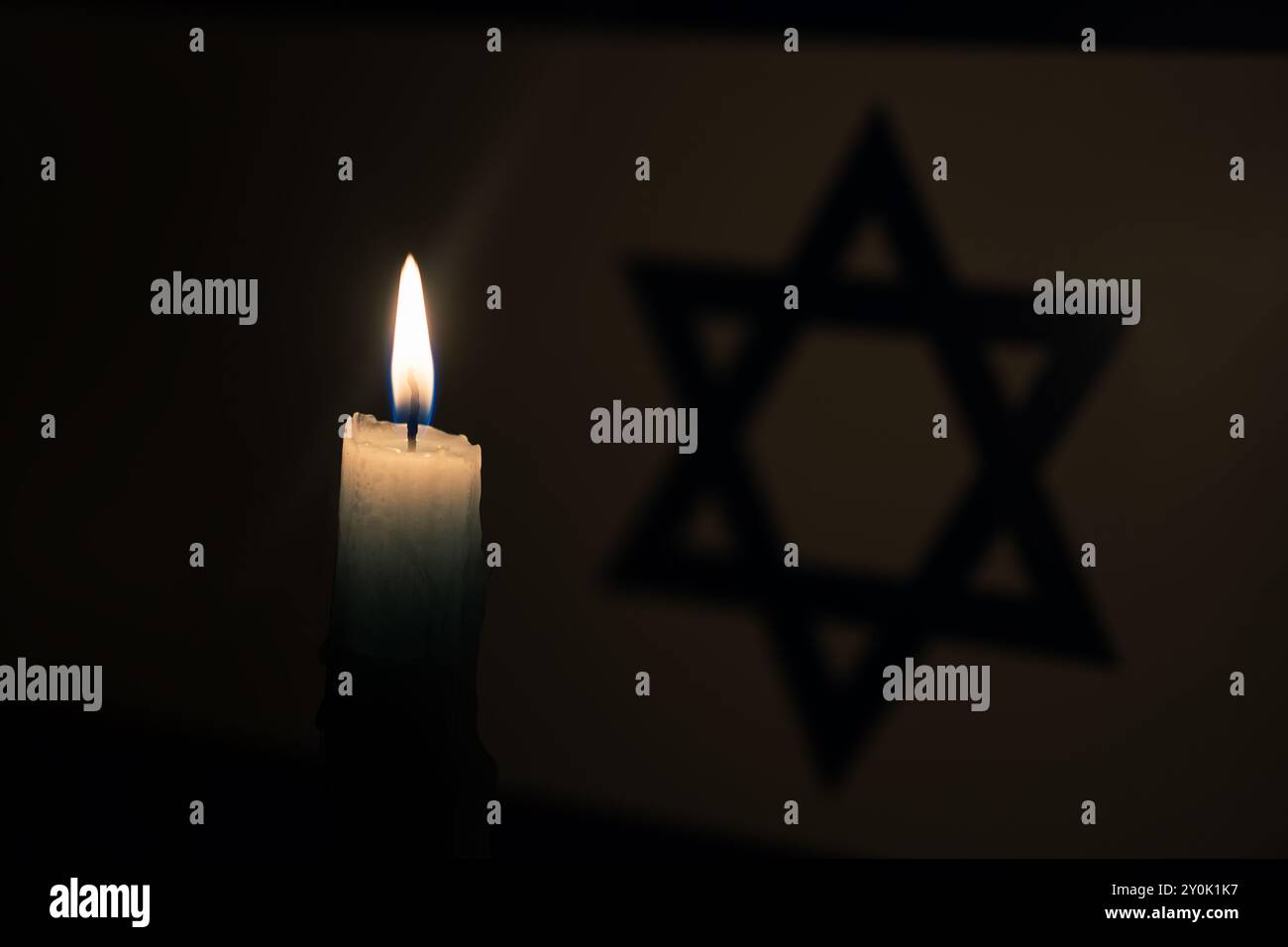 Lutto nel paese Israele. Una candela accesa sullo sfondo della bandiera israeliana. Vittime del cataclisma o del concetto di guerra. Memorial Day dell'Olocausto, Remem Foto Stock