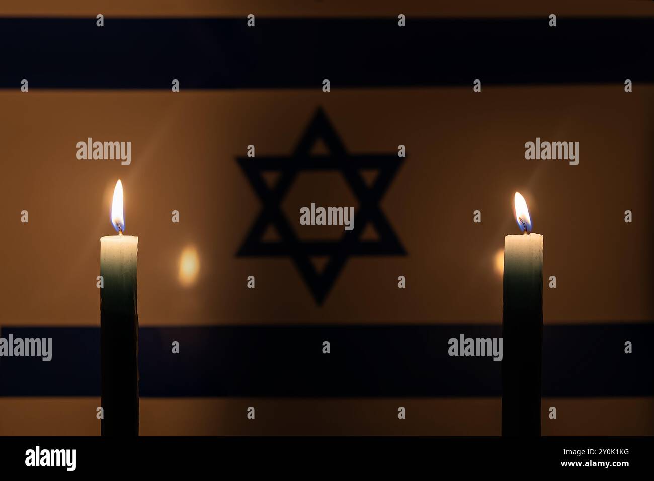 Lutto nel paese Israele. Una candela accesa sullo sfondo della bandiera israeliana. Vittime del cataclisma o del concetto di guerra. Memorial Day dell'Olocausto, Remem Foto Stock