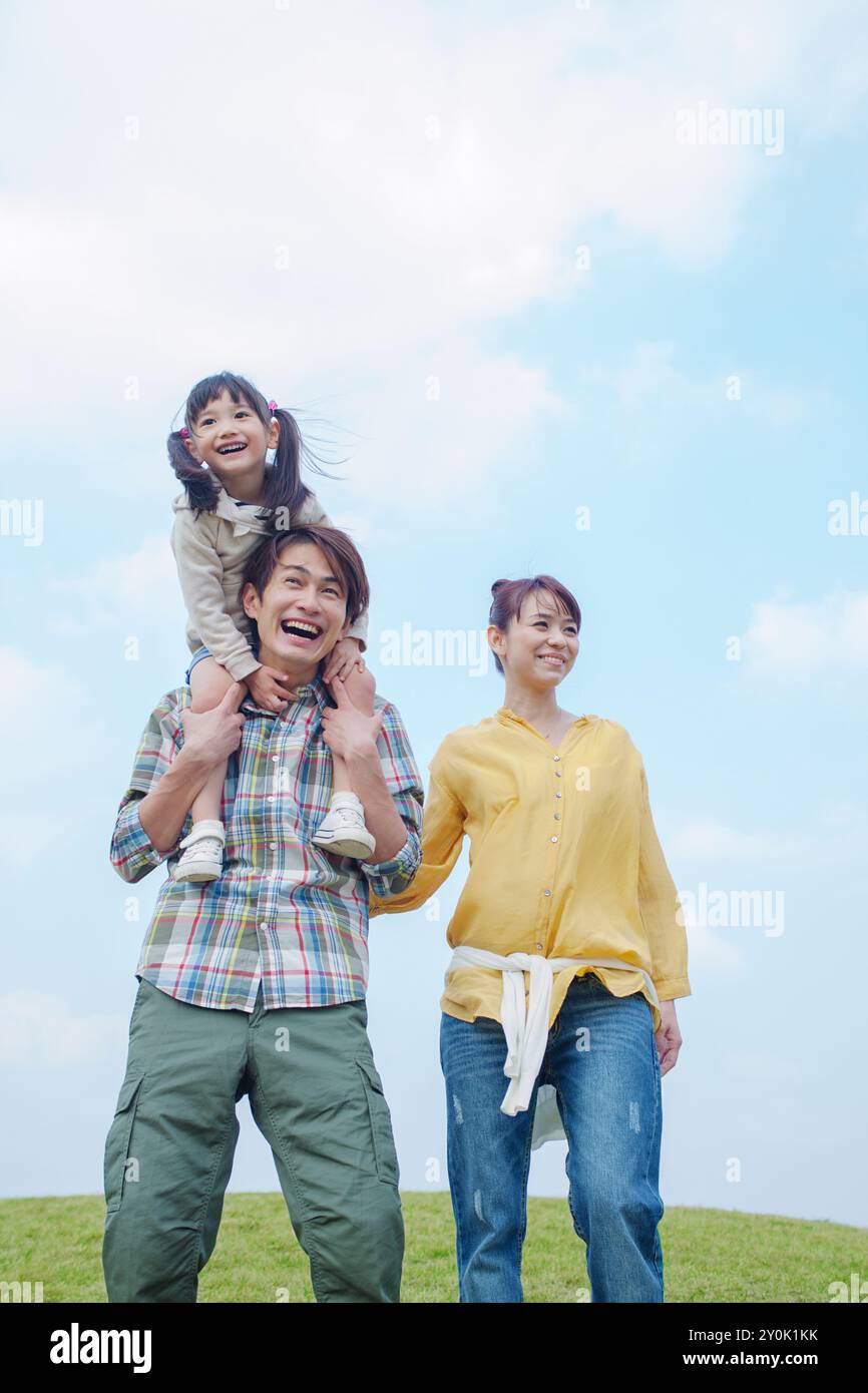 Il cielo blu e una famiglia giapponese sorridente Foto Stock