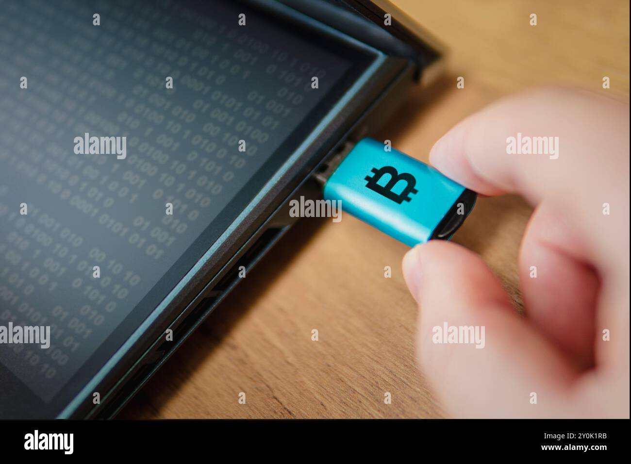 Portafoglio hardware per criptovaluta collegato a un laptop in mano all'uomo. un modo freddo per archiviare le criptovalute su un vettore portatile è un modo per proteggere savin Foto Stock