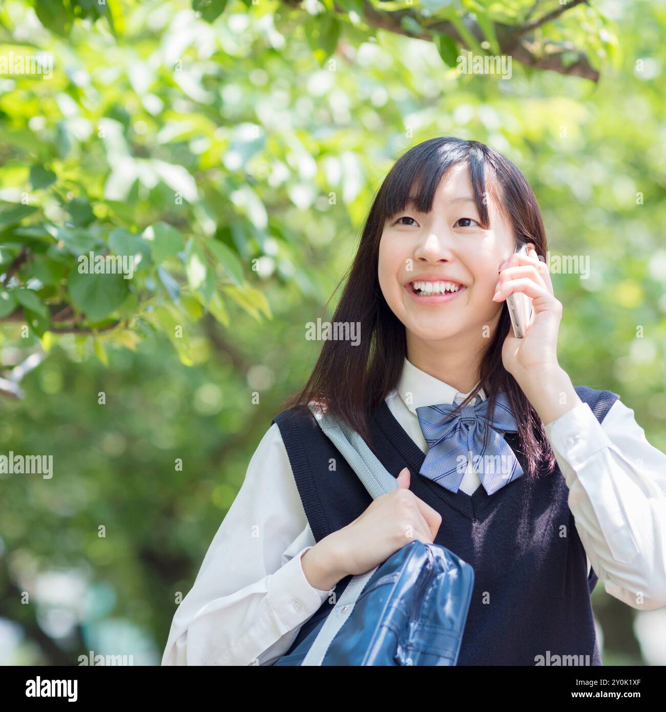 Studentessa giapponese che parla ai cellulari Foto Stock