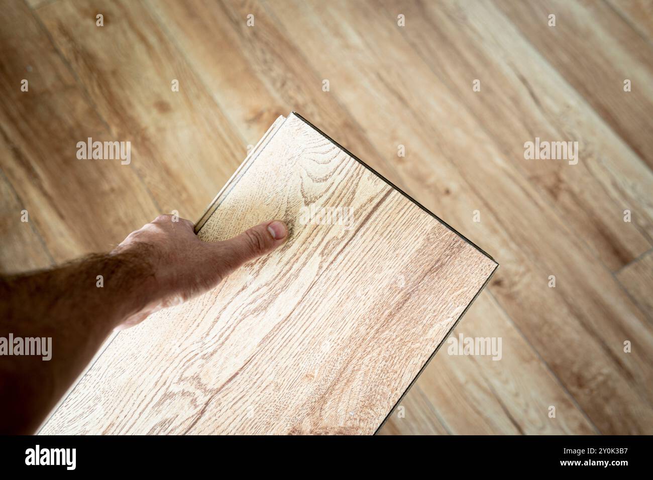 Pavimento in parquet laminato in legno, scelta di colori con vista dall'alto. Parquet in mano al maestro. Foto Stock
