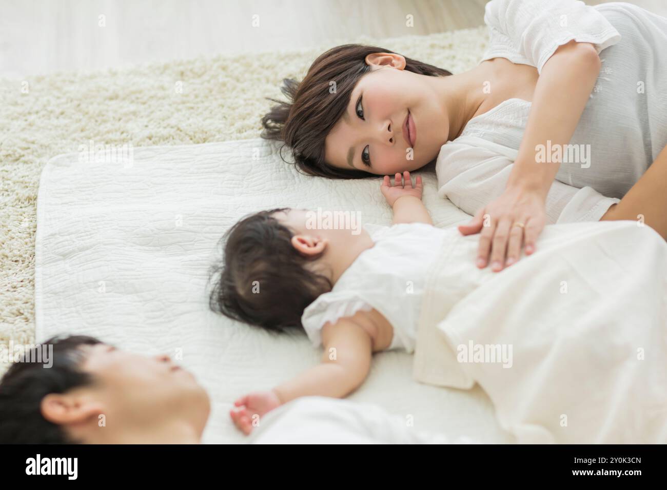 Genitori che guardano un bambino che dorme Foto Stock
