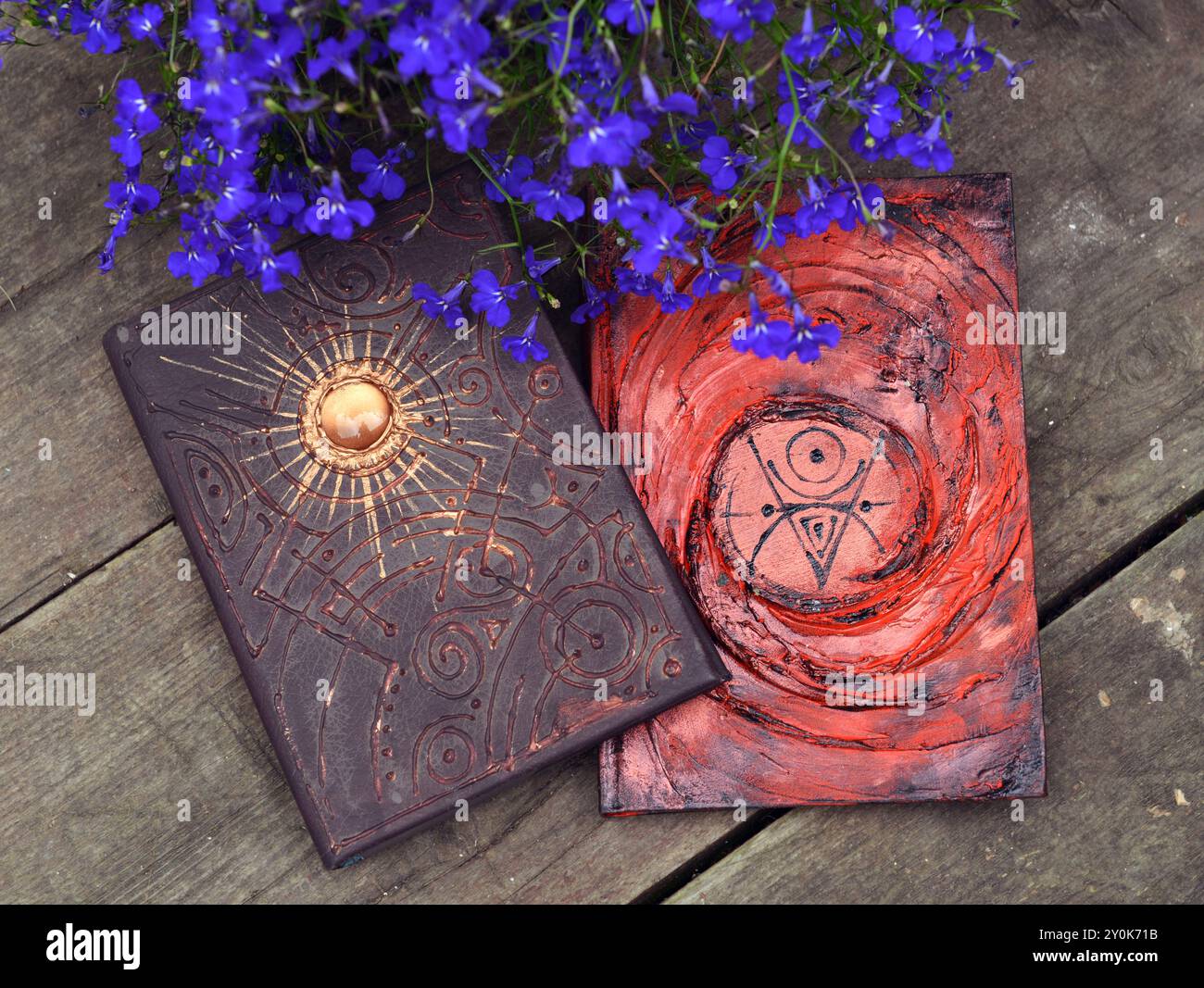 Mystic Still Life con un libro magico di incantesimi e fiori su un vecchio tavolo di legno. Occulto, esoterico, wicca e sfondo di divinazione. Lettura e conoscenza Foto Stock