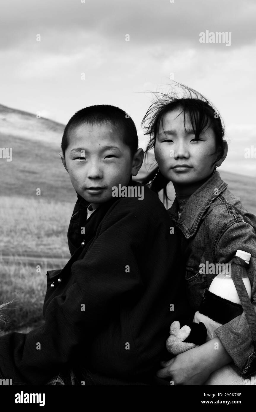 Fratelli mongoli che cavalcano nella valle dell'Orkhon nella Mongolia centrale. Foto Stock