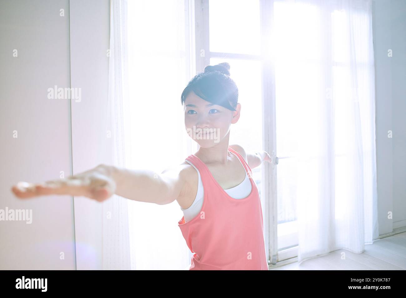 Donna che pratica yoga alla finestra Foto Stock